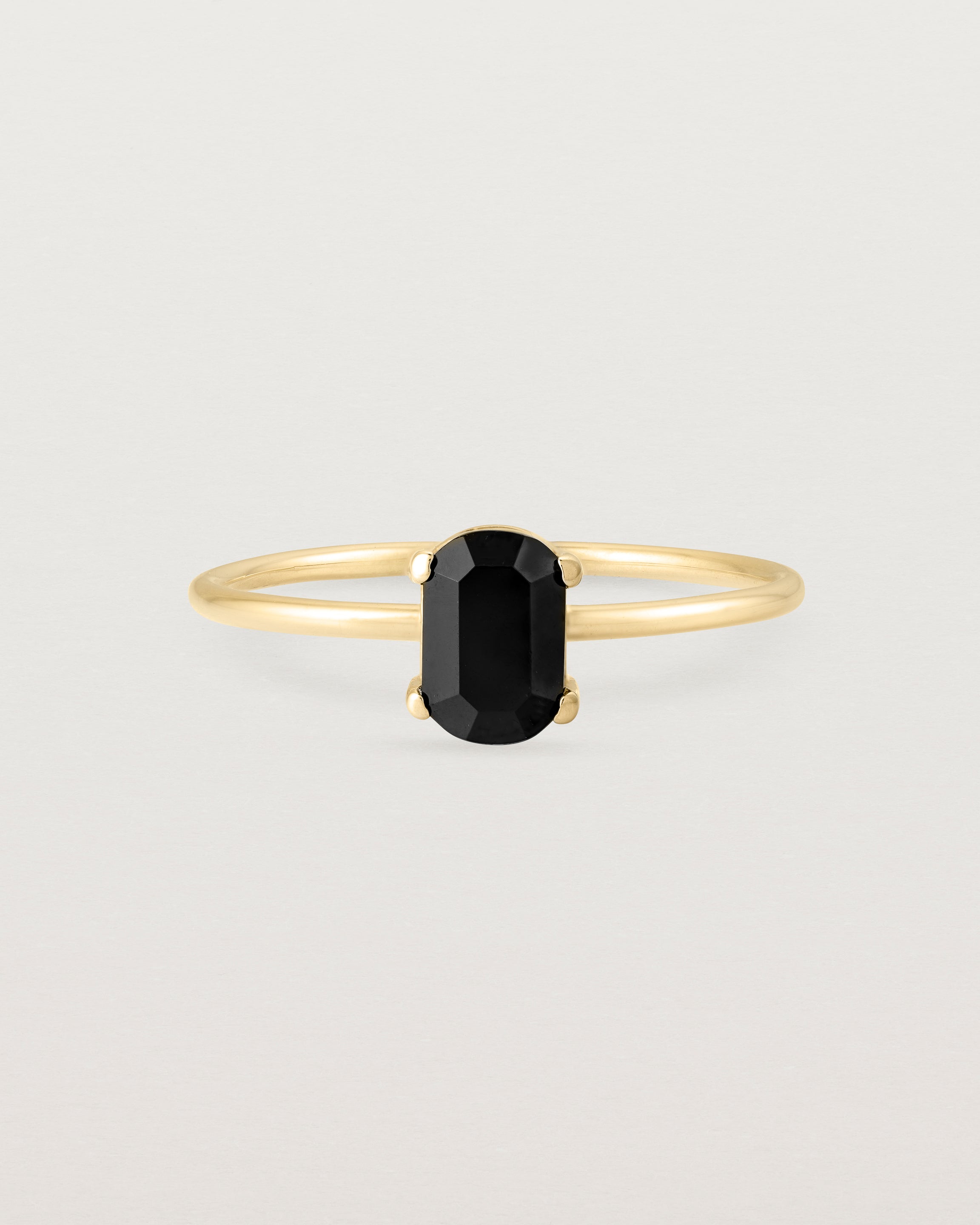 Fine yellow gold band featuring an oval black spinel stone