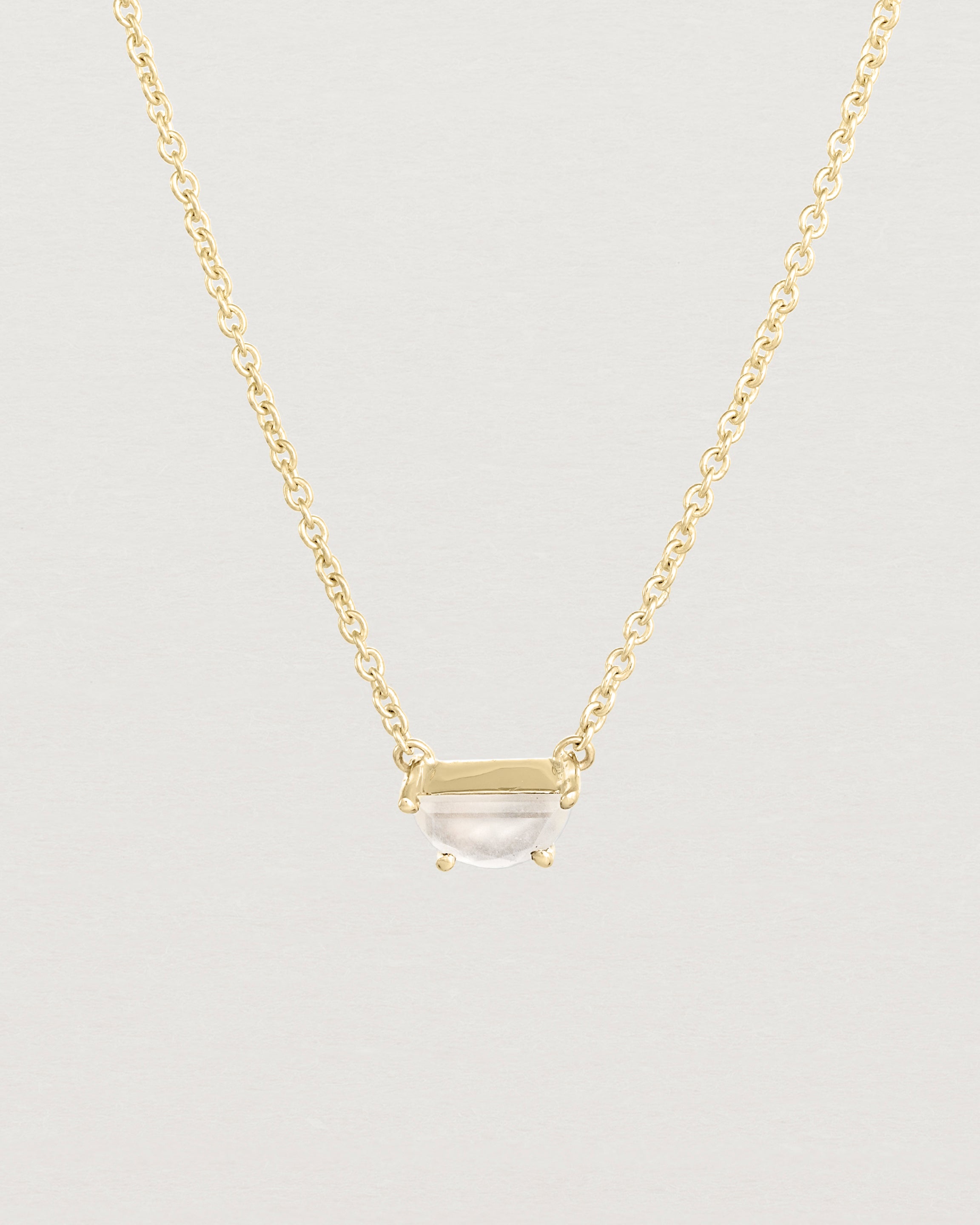Close up view of the Tiny Half Moon Pendant | Moonstone in yellow gold.