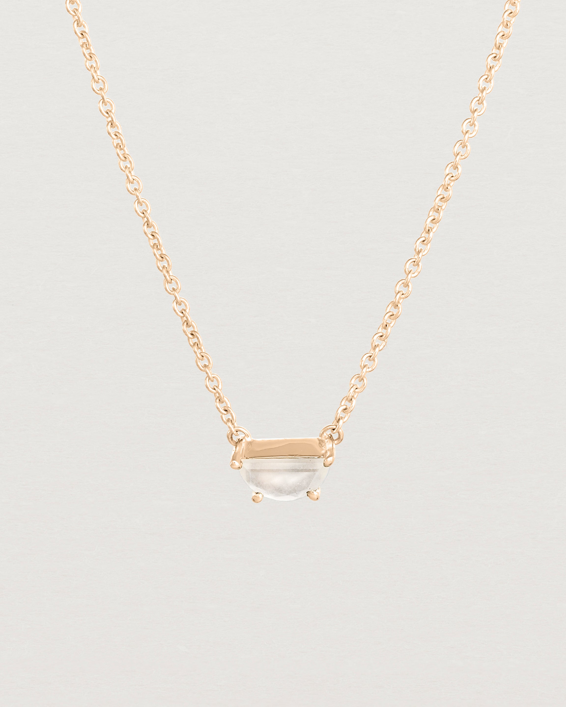 Close up view of the Tiny Half Moon Pendant | Moonstone in rose gold.
