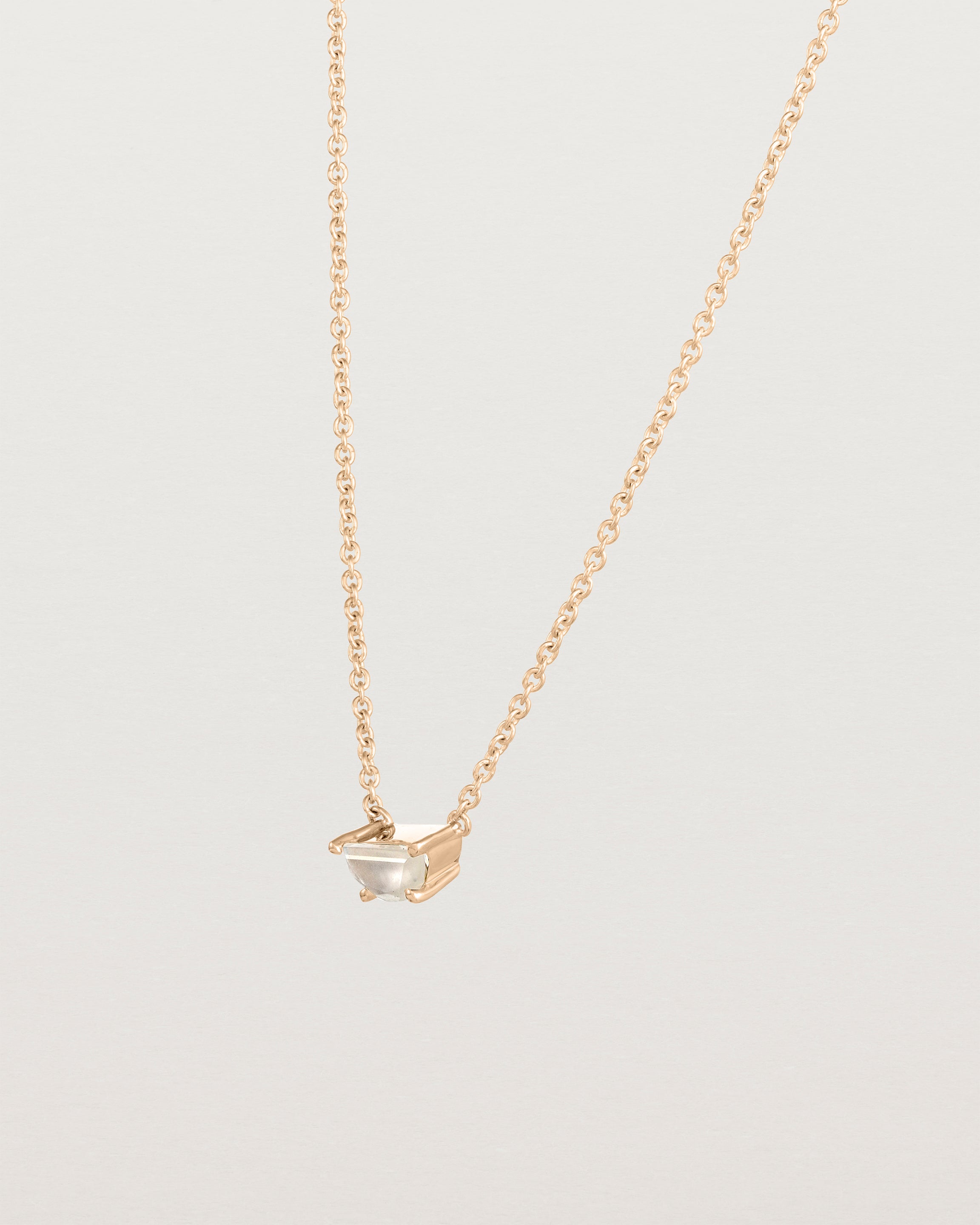 Angled view of the Tiny Half Moon Pendant | Moonstone in rose gold.