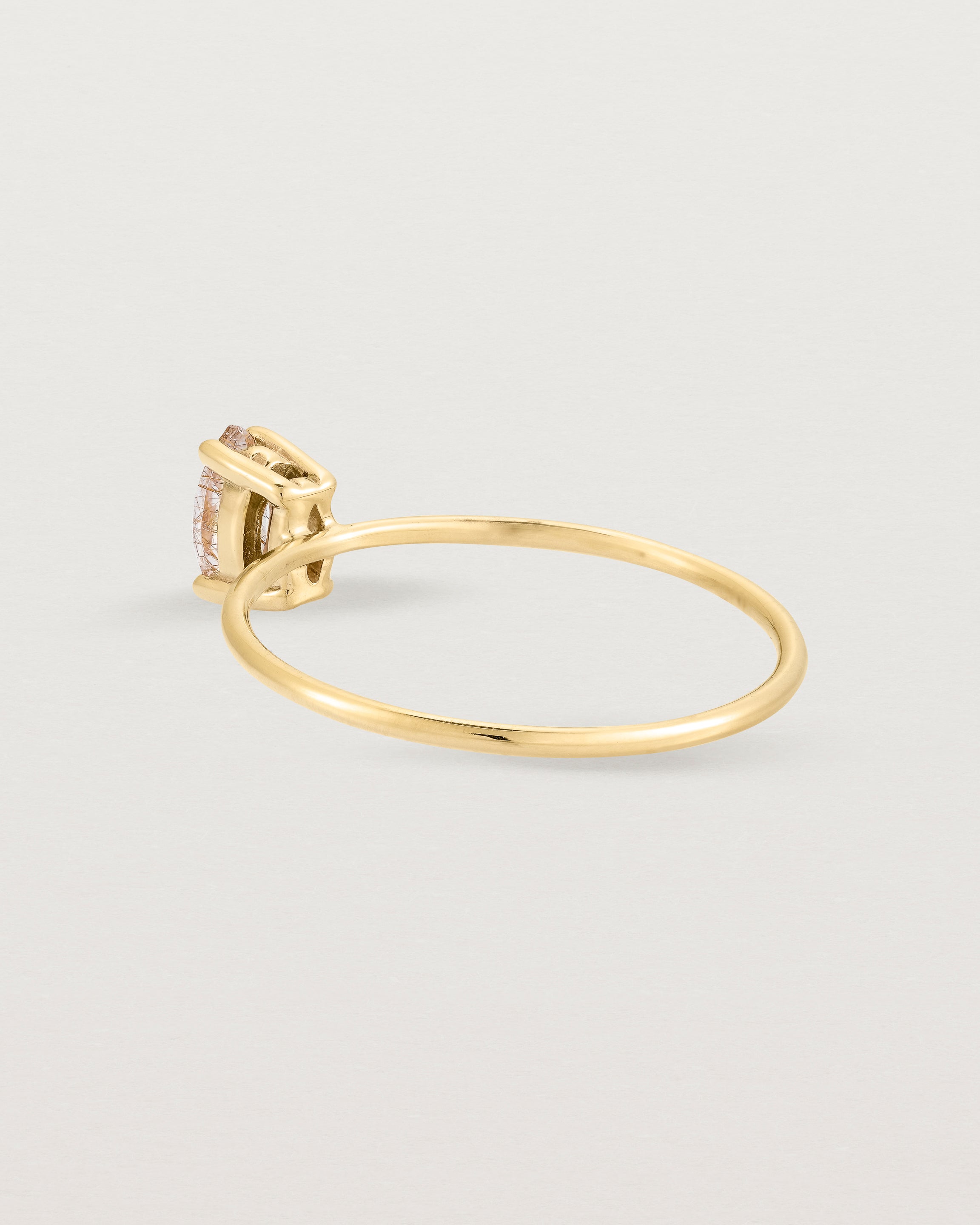 Fine yellow gold band featuring a marquise cut brown rutilated quartz stone