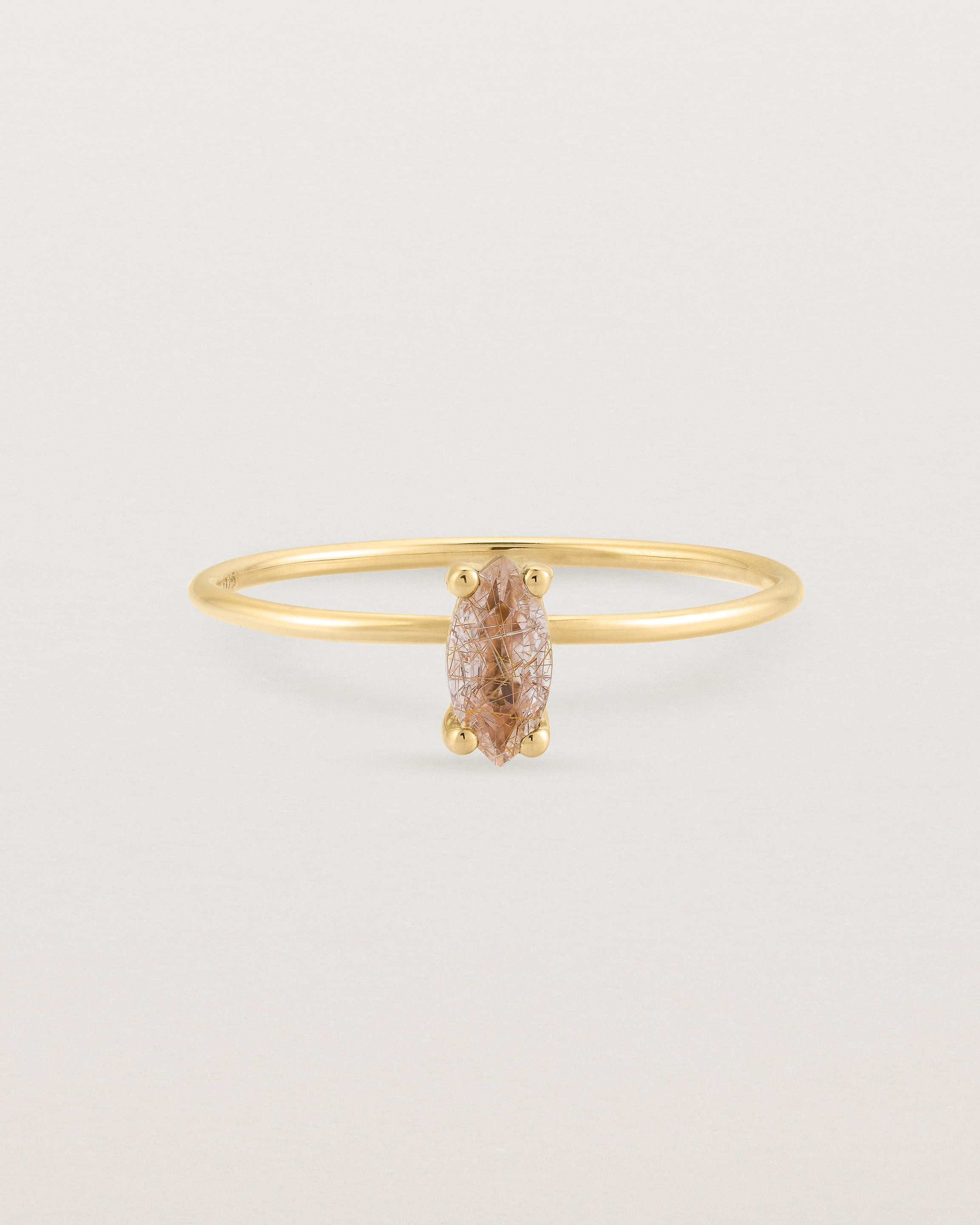 Fine yellow gold band featuring a marquise cut brown rutilated quartz stone