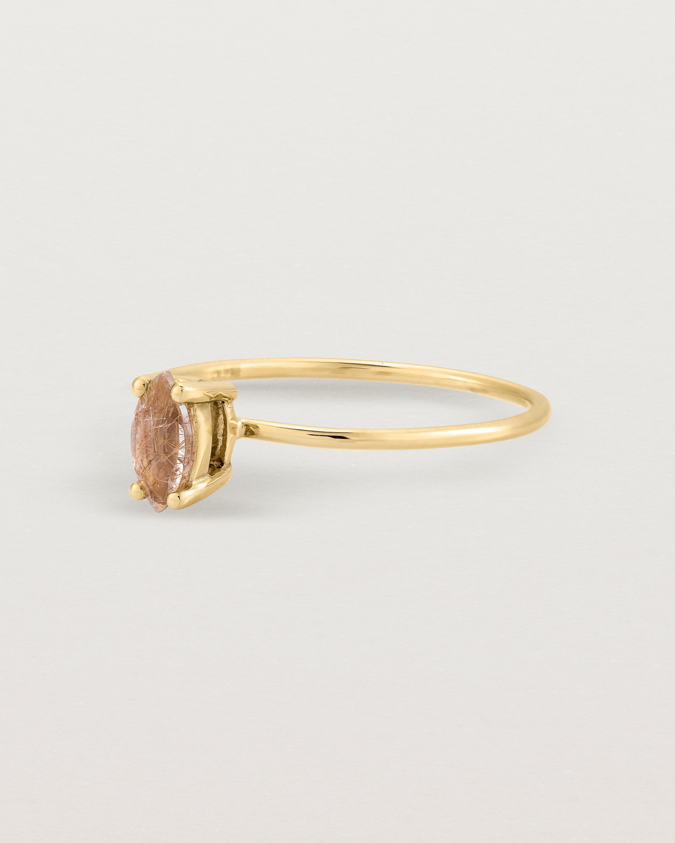 Fine yellow gold band featuring a marquise cut brown rutilated quartz stone