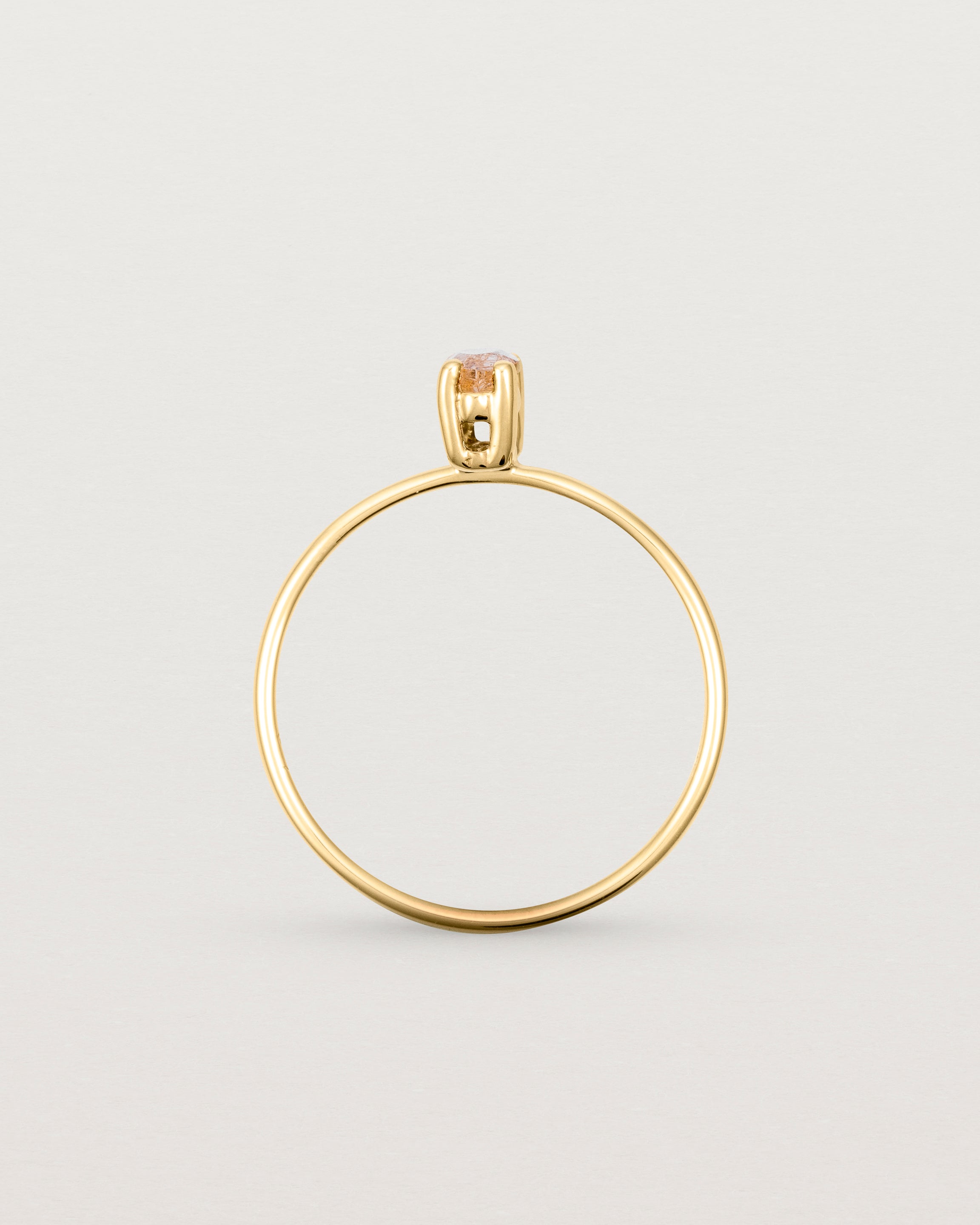 Fine yellow gold band featuring a marquise cut brown rutilated quartz stone