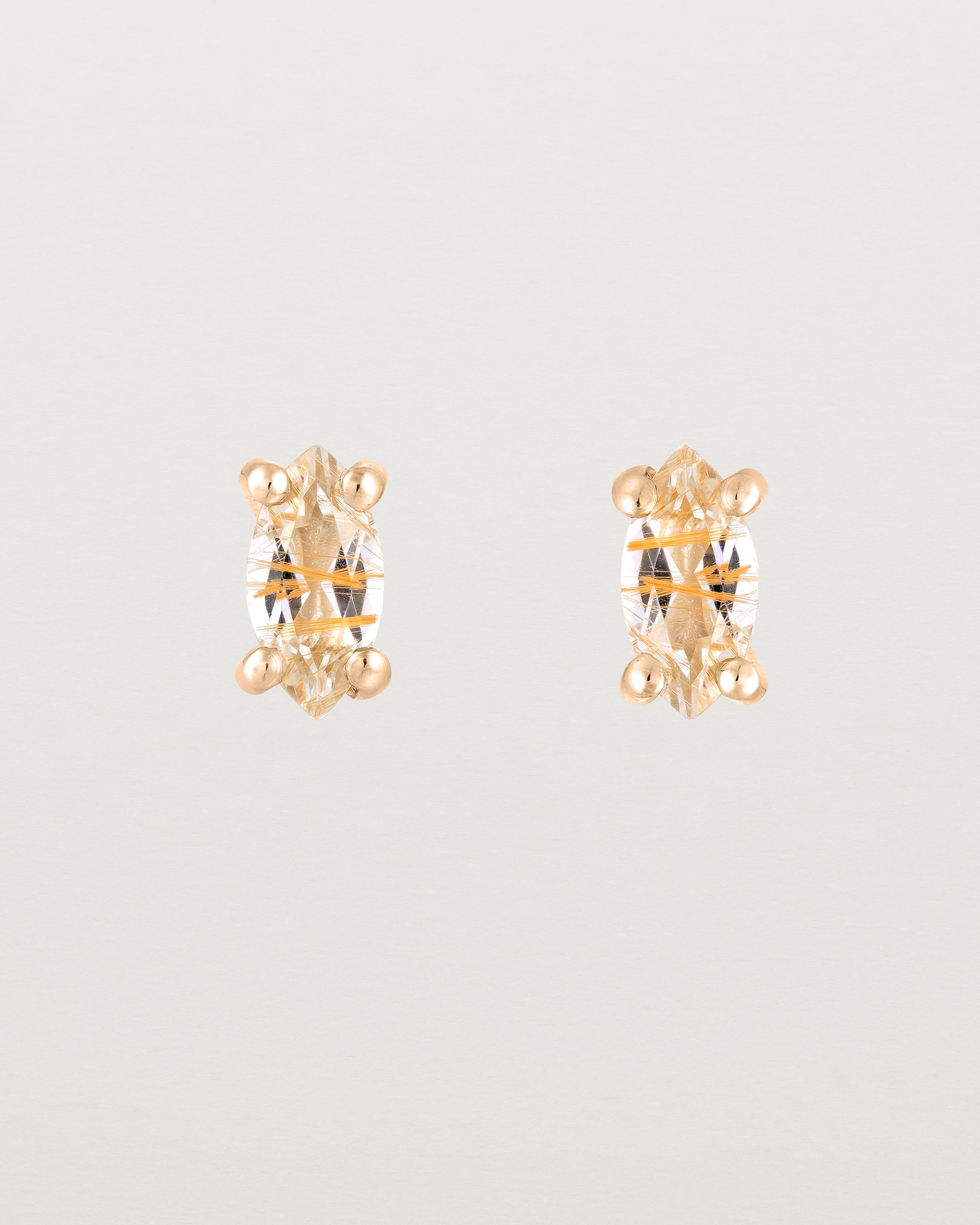 A pair of rose gold studs featuring a marquise shaped light yellow rutilated quartz