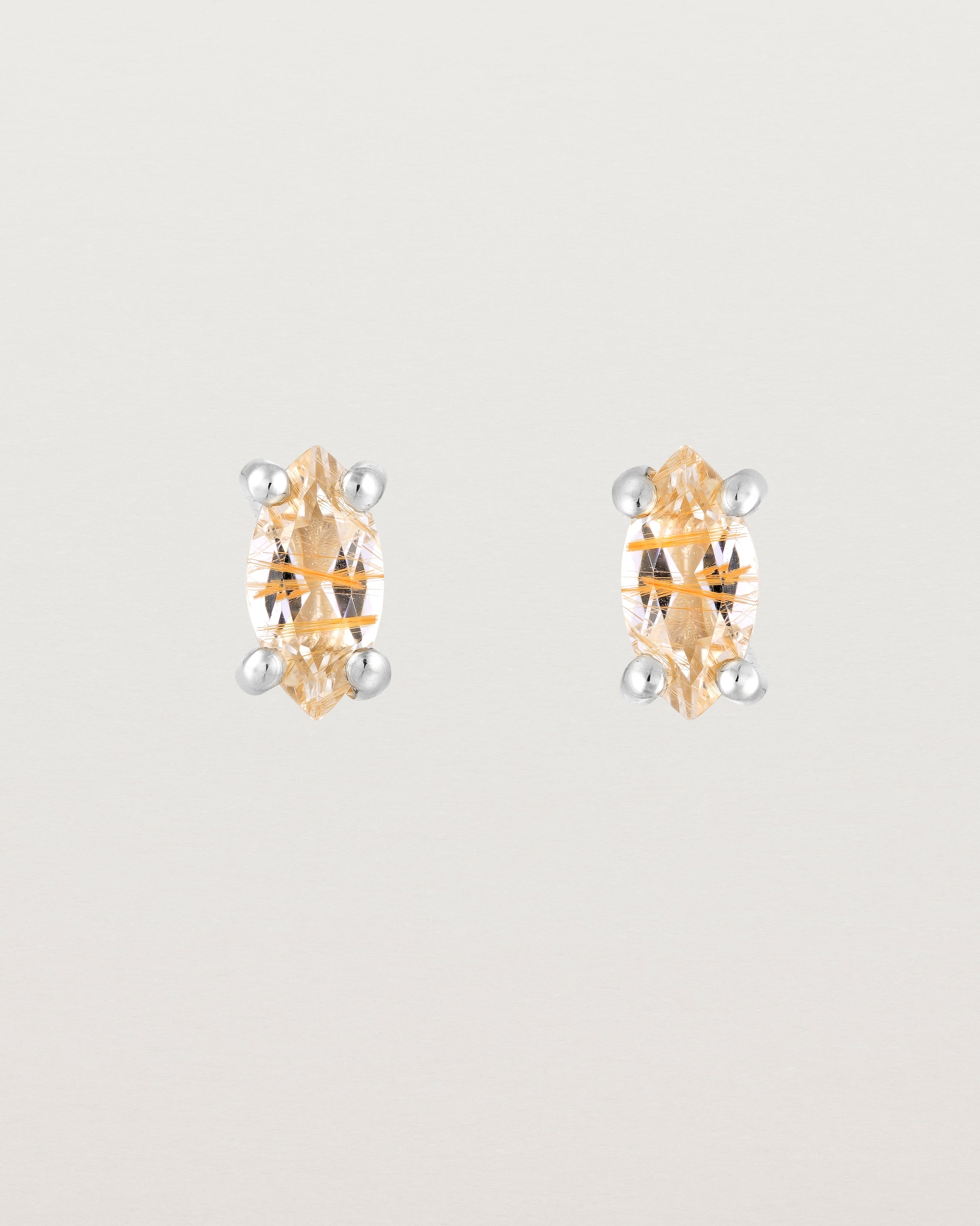 A pair of sterling silver studs featuring a marquise shaped light yellow rutilated quartz