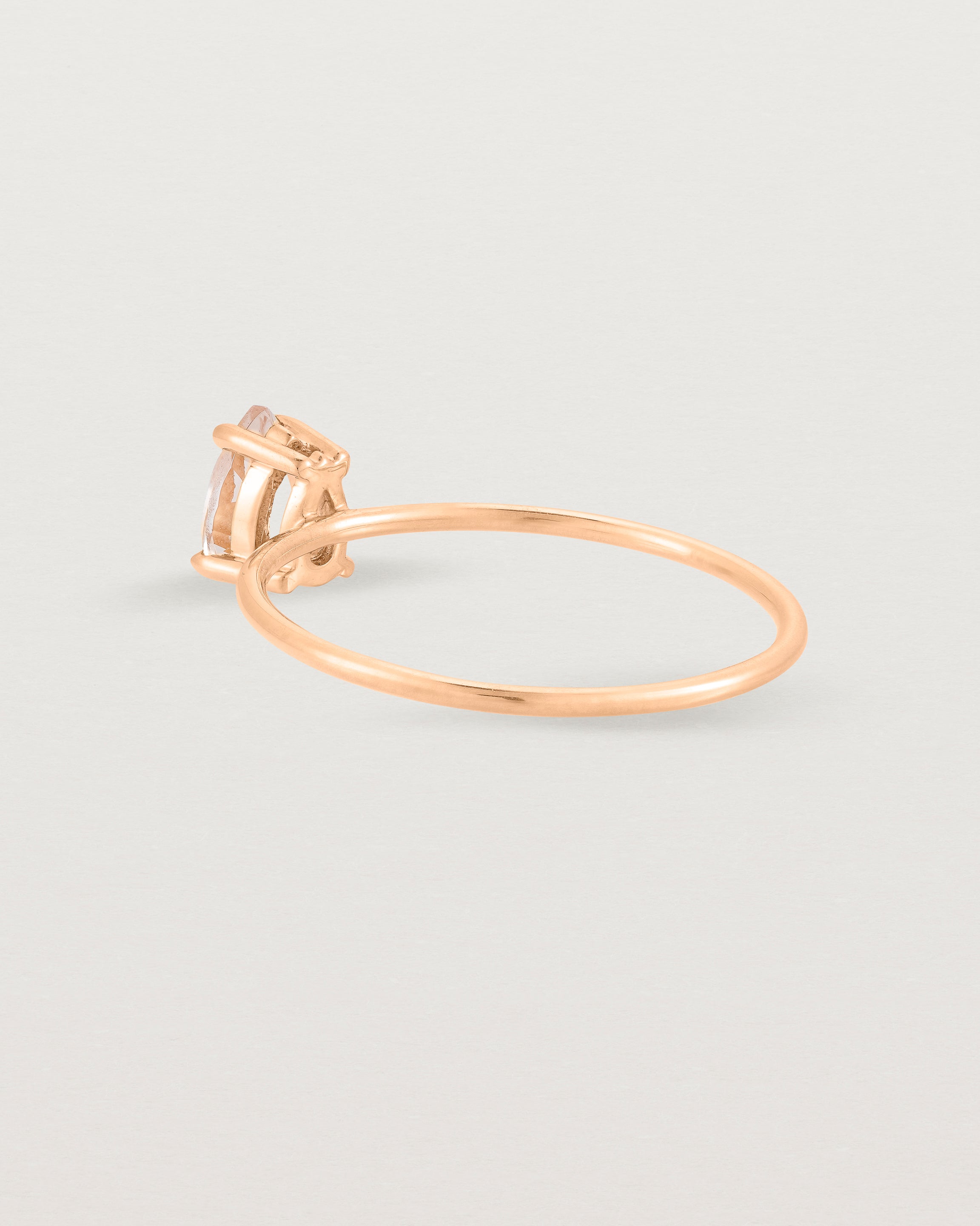 A fine rose gold ring featuring a pear shaped pink morganite stone