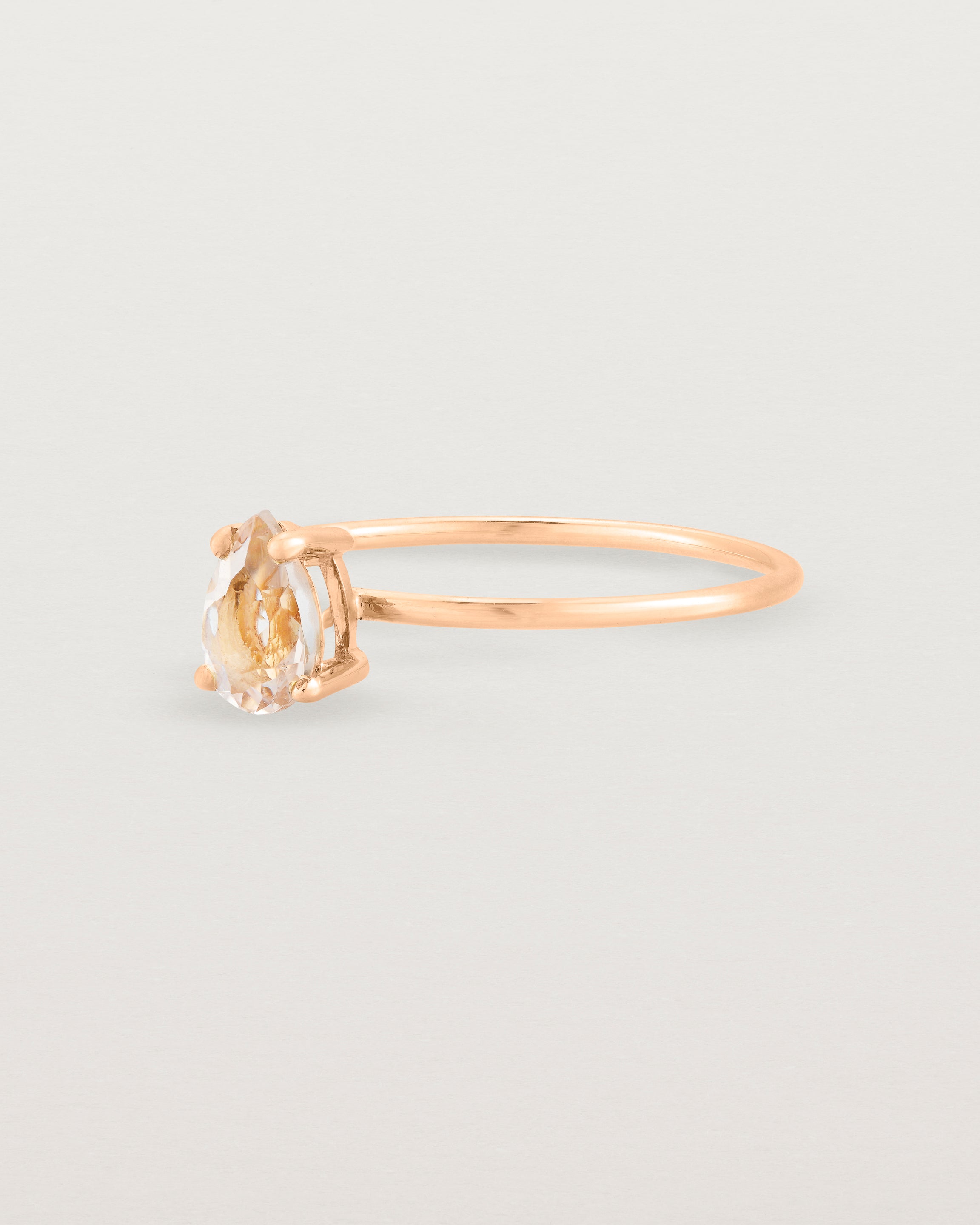 A fine rose gold ring featuring a pear shaped pink morganite stone