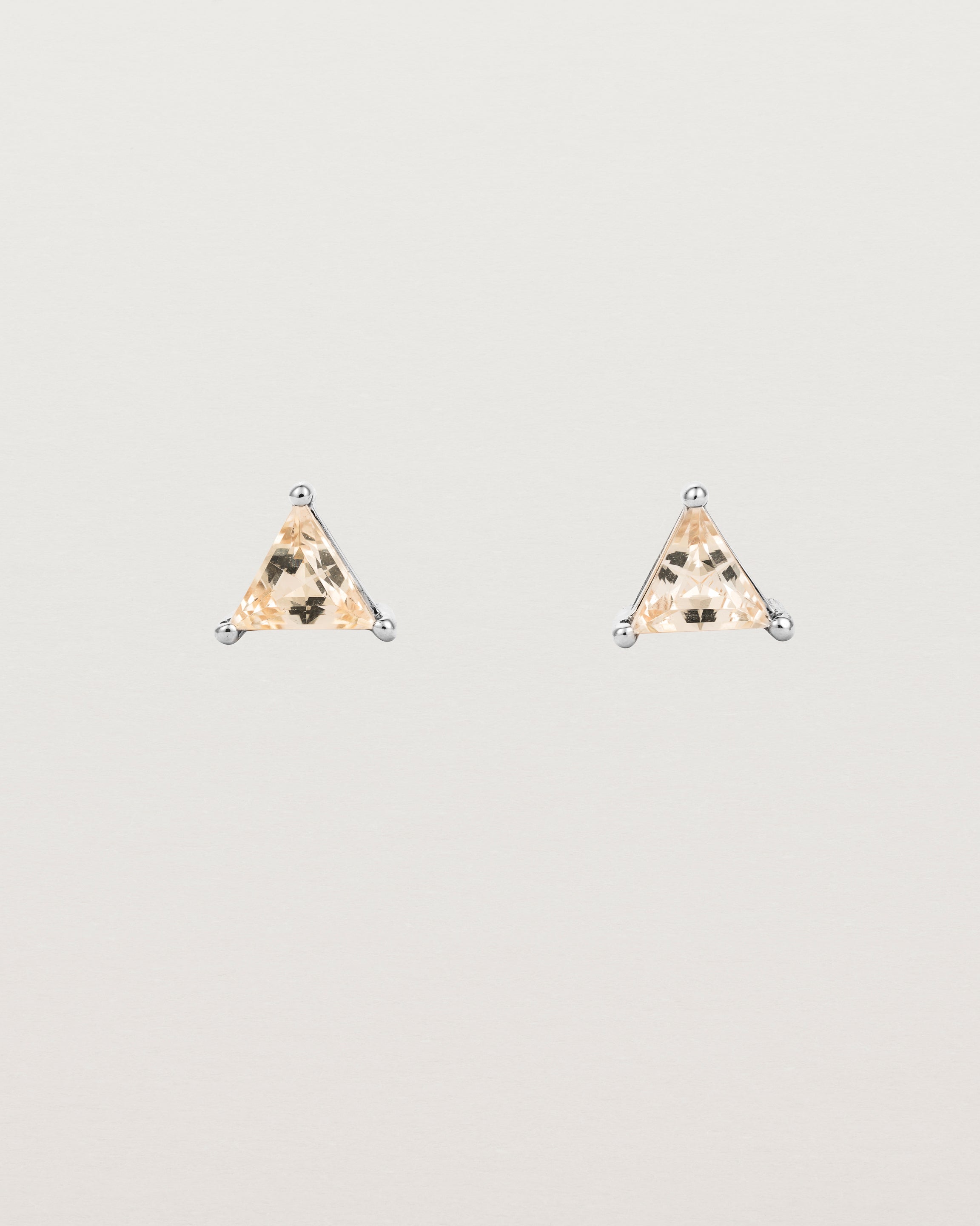 A pair of sterling silver studs featuring a triangle shaped rutilated quartz