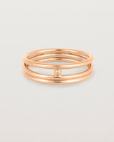 layered rose gold ring featuring a yellow gold ball suspended between two bands