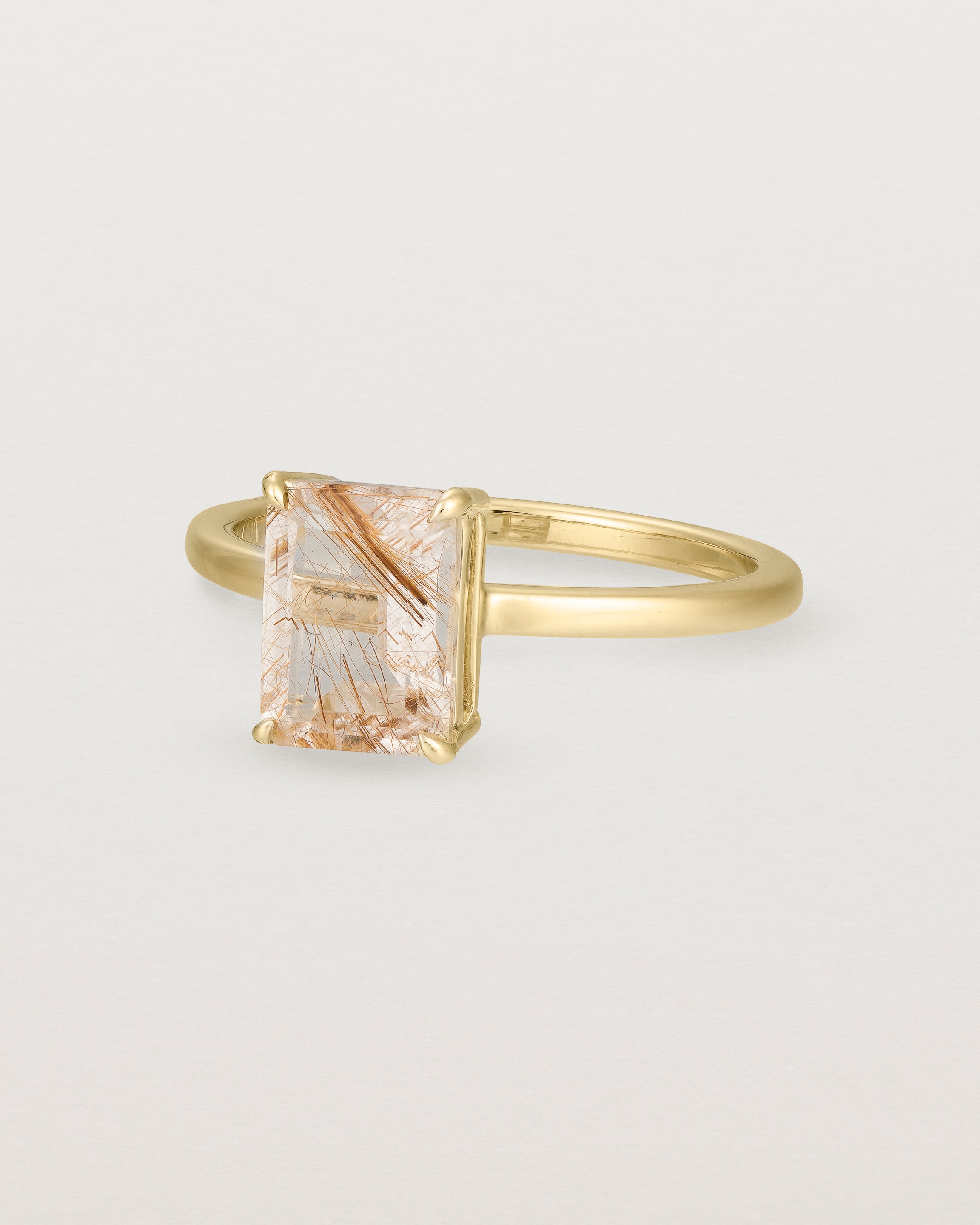 Angled view of the Una Emerald Solitaire | Rutilated Quartz | Yellow Gold.