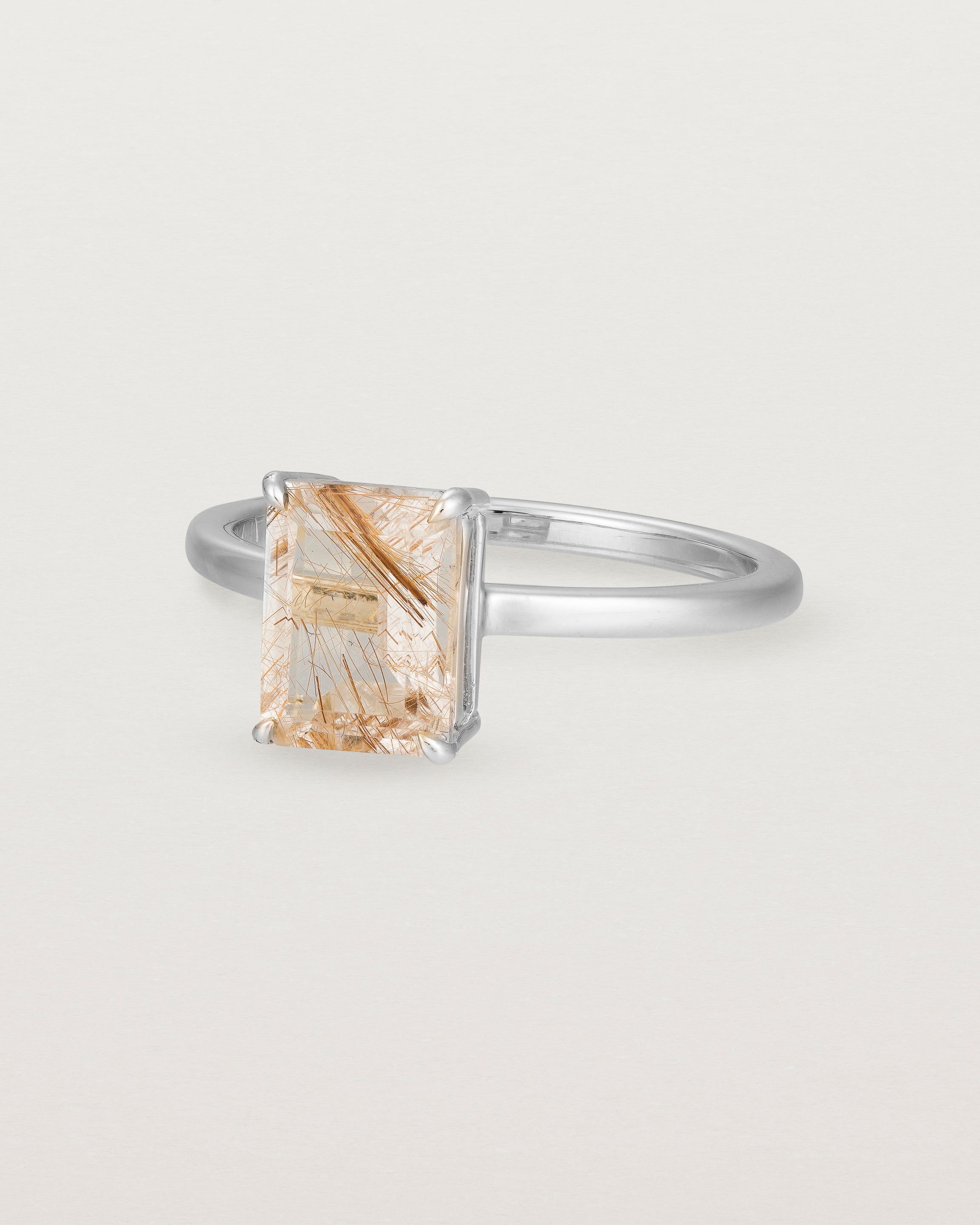 Angled view of the Una Emerald Solitaire | Rutilated Quartz | White Gold.