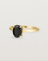 Angled view of the Una Oval Solitaire | Black Spinel | Yellow Gold.
