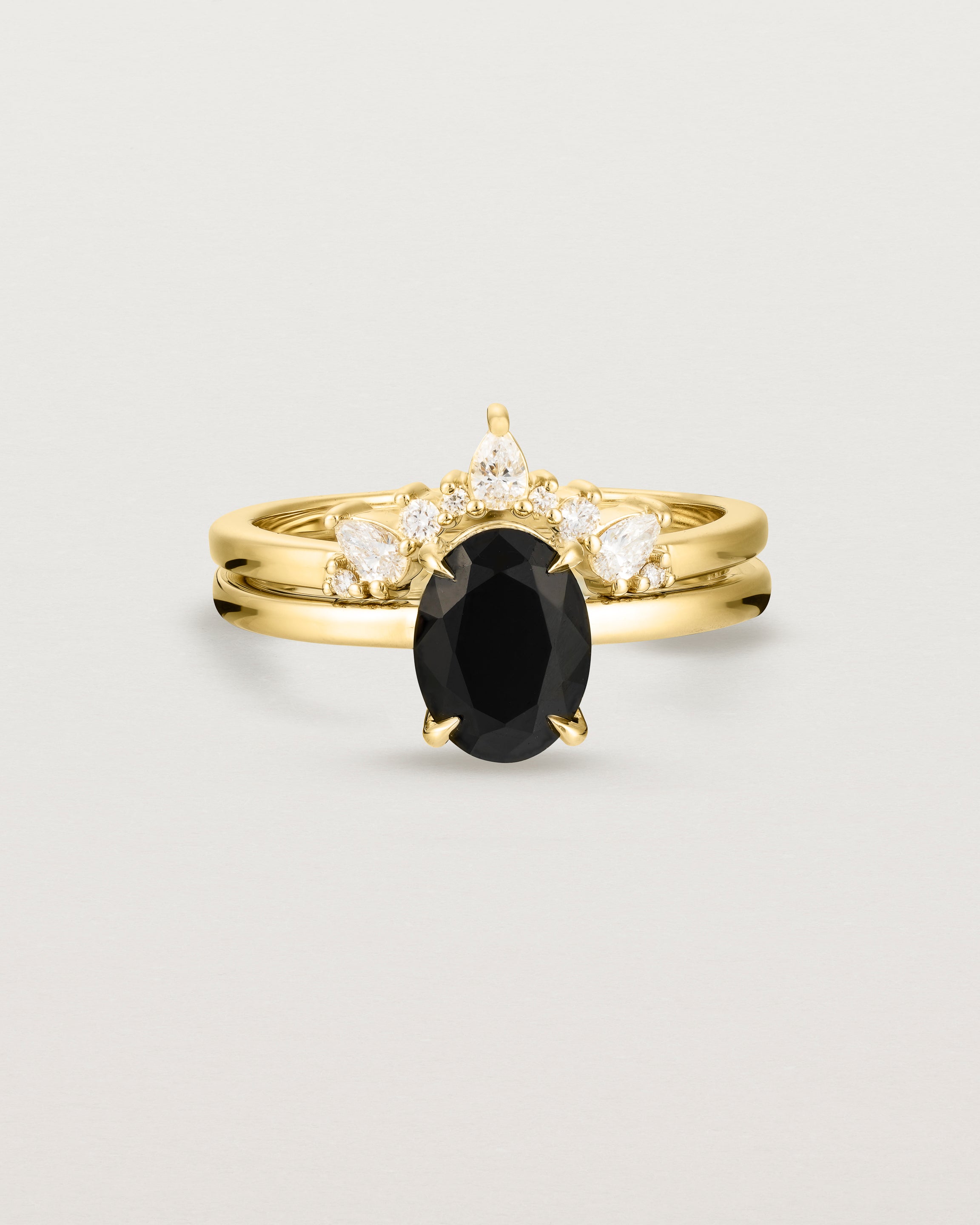 Front view of the Una Oval Solitaire | Black Spinel | Yellow Gold stacked with the Odette Crown Ring.