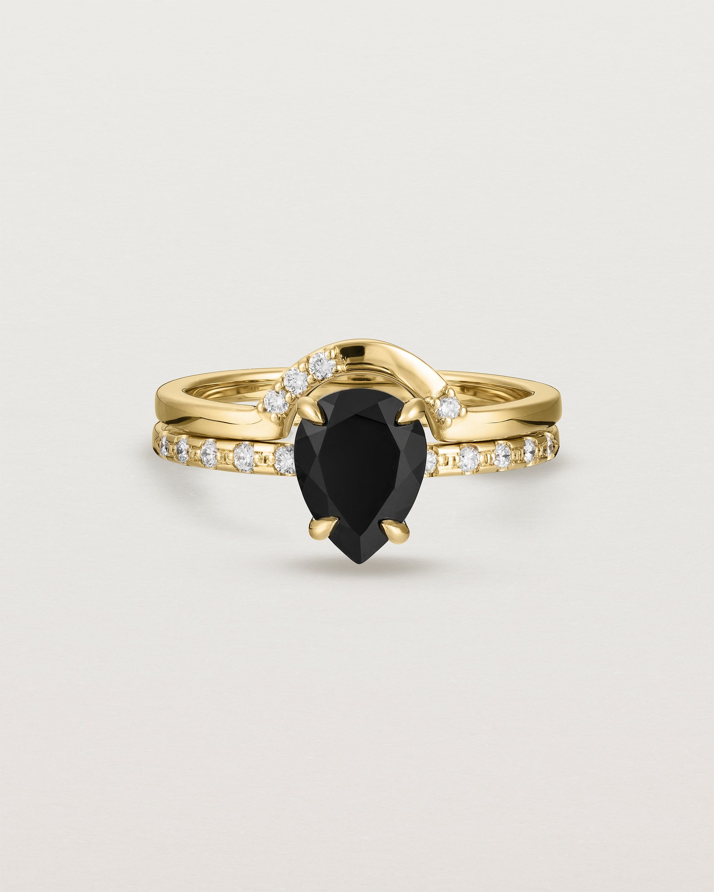 Front view of the Una Pear Solitaire | Black Spinel | Yellow Gold with Cascade Shoulders stacked with Cecile Crown Ring | Diamonds.