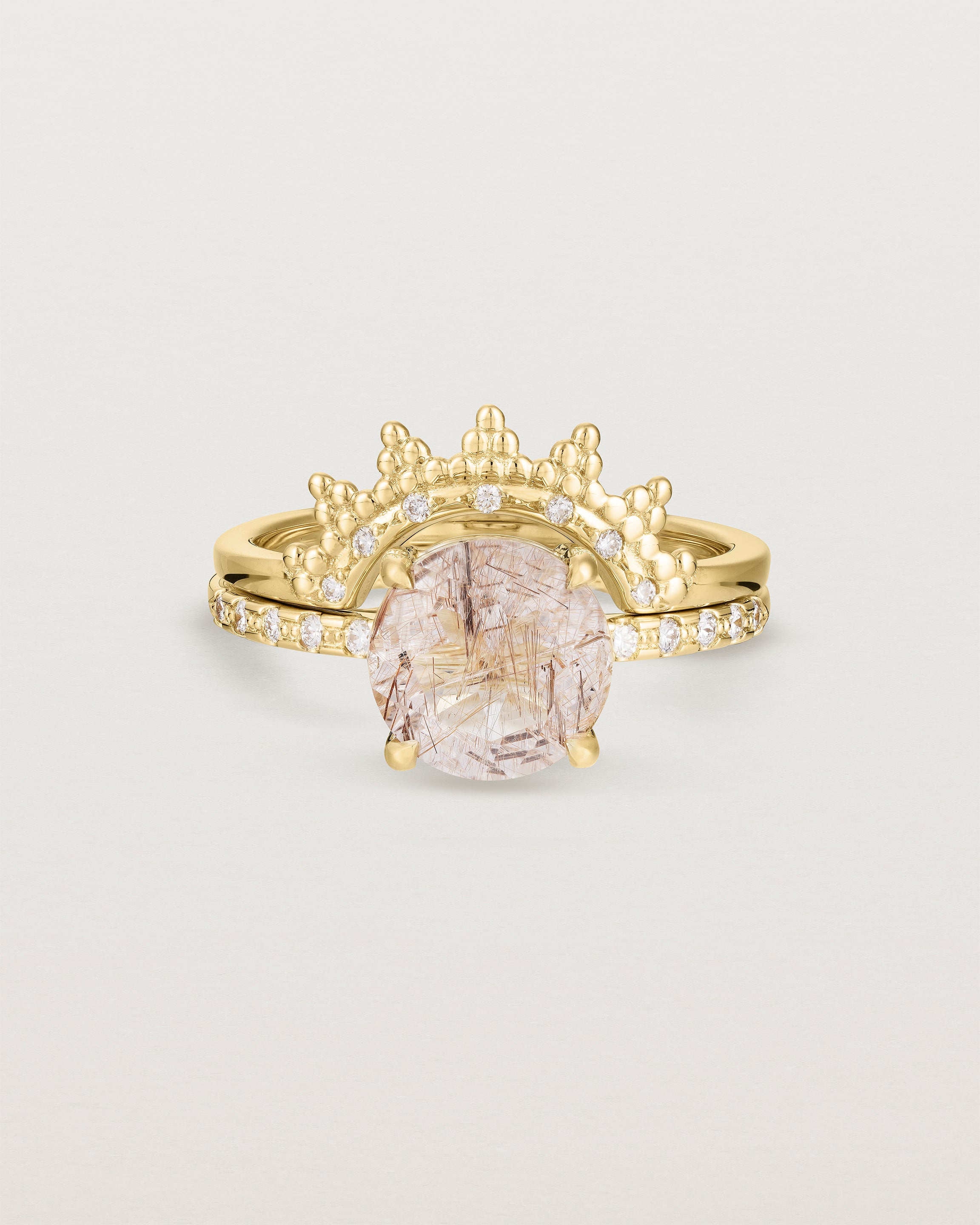 Front view of the Front view of the Una Round Solitaire | Rutilated Quartz | Yellow Gold with Cascade Shoulders paired with the Odine Crown Ring. 