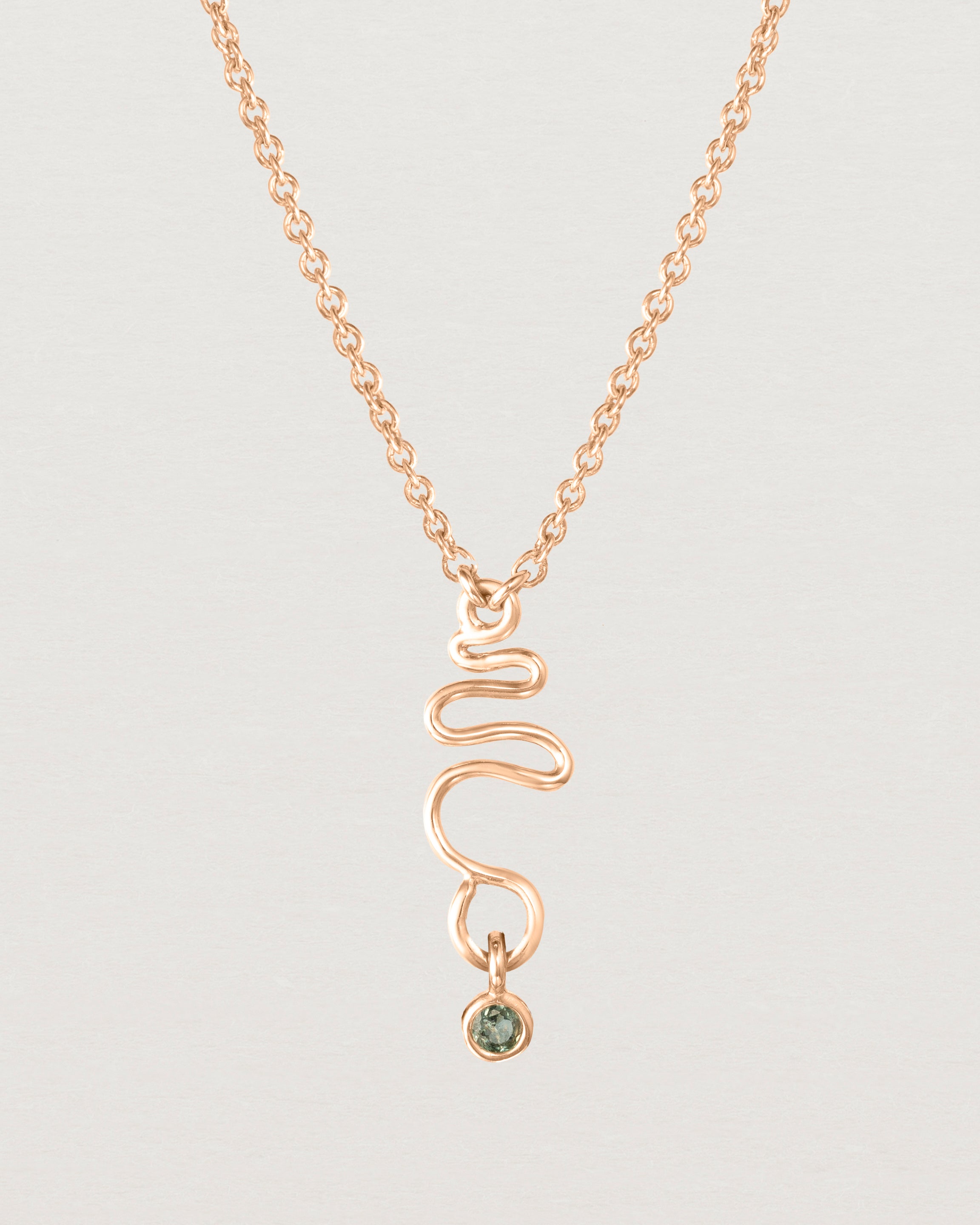 Front on deep etched image of a rose gold necklace with birthstone charms.