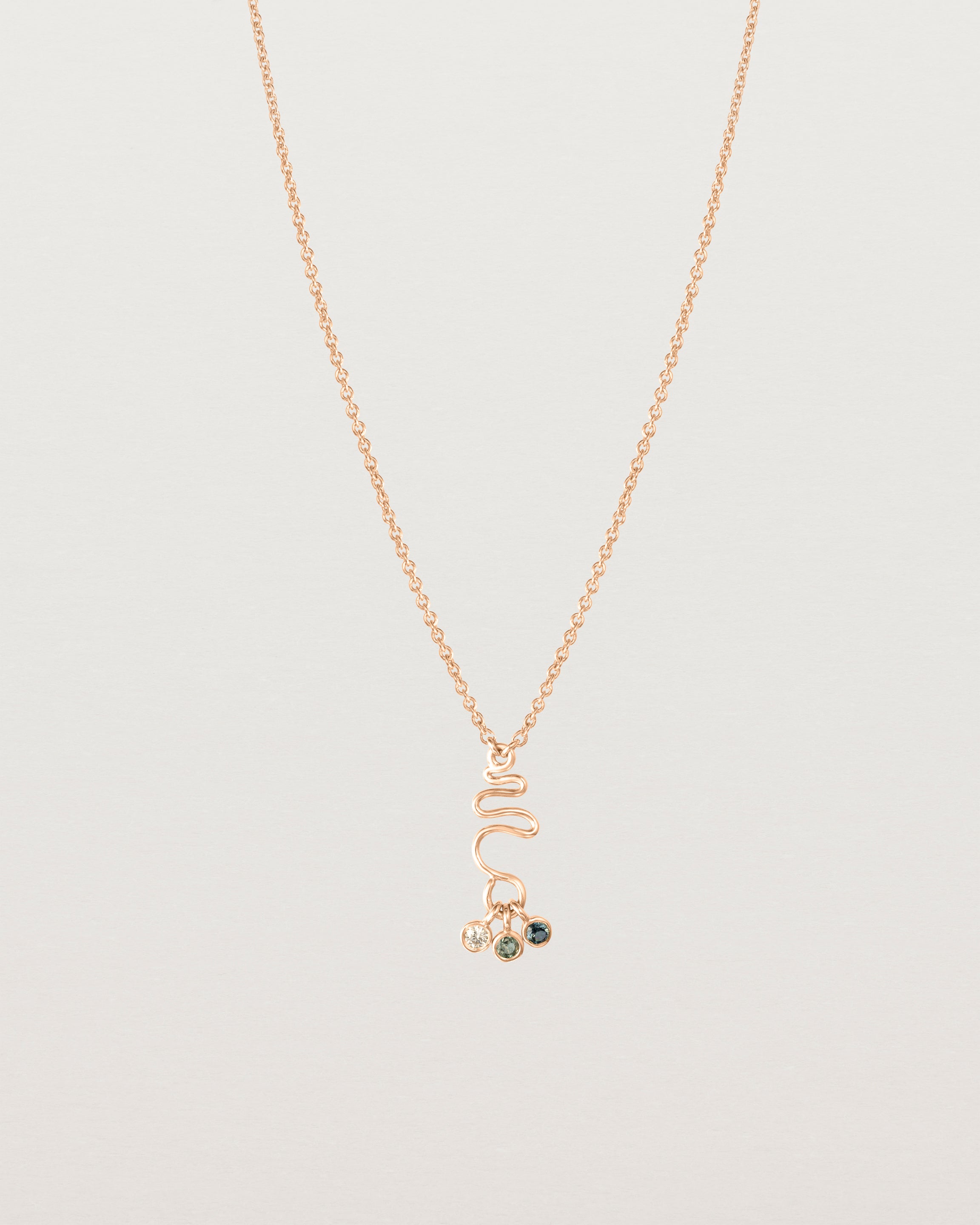 Front on deep etched image of a rose gold necklace with birthstone charms.