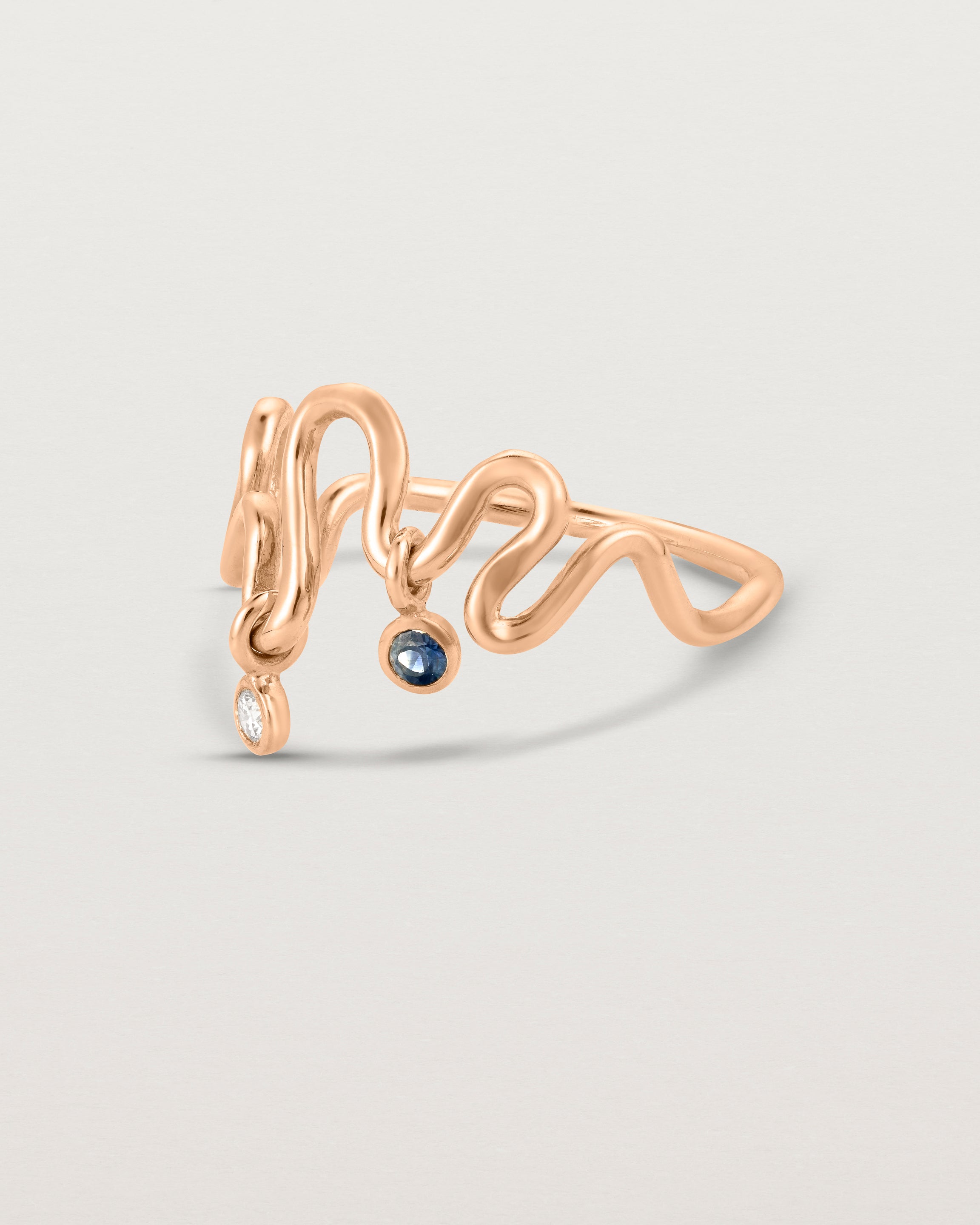 Side facing deep etched image of a rose gold ring with birthstone charms.