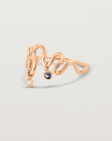 Side facing deep etched image of a rose gold ring with birthstone charms.