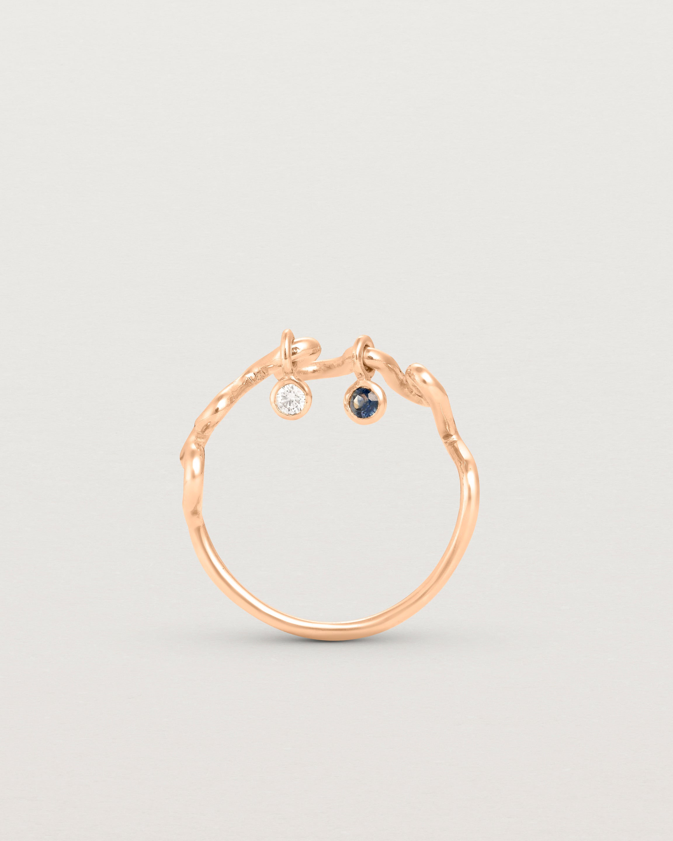 Standing deep etched image of a rose gold ring with birthstone charms.