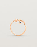 Standing deep etched image of a rose gold ring with birthstone charms.