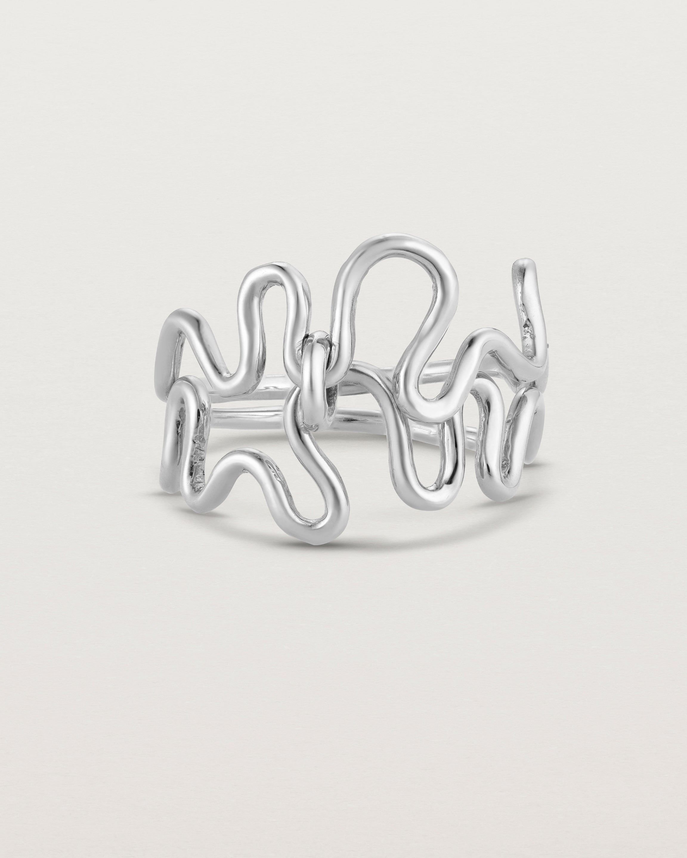 Side facing deep etched image of a white gold ring set with charms.
