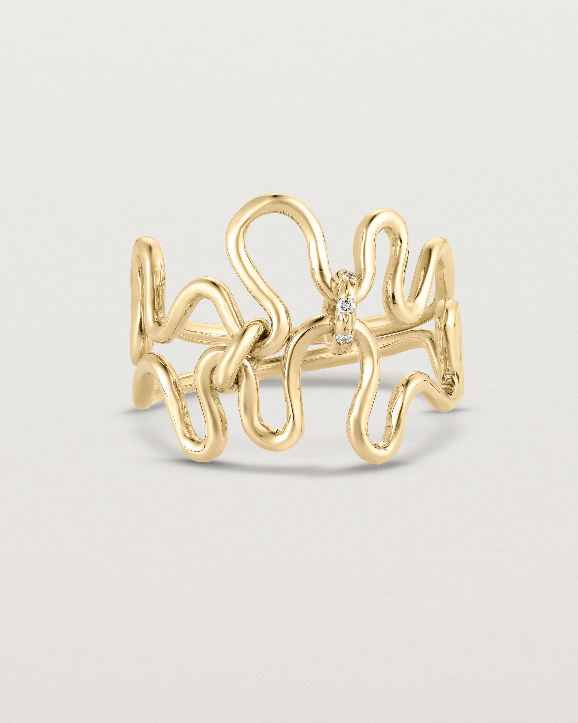 Front facing deep etched image of a yellow gold ring set with charms.