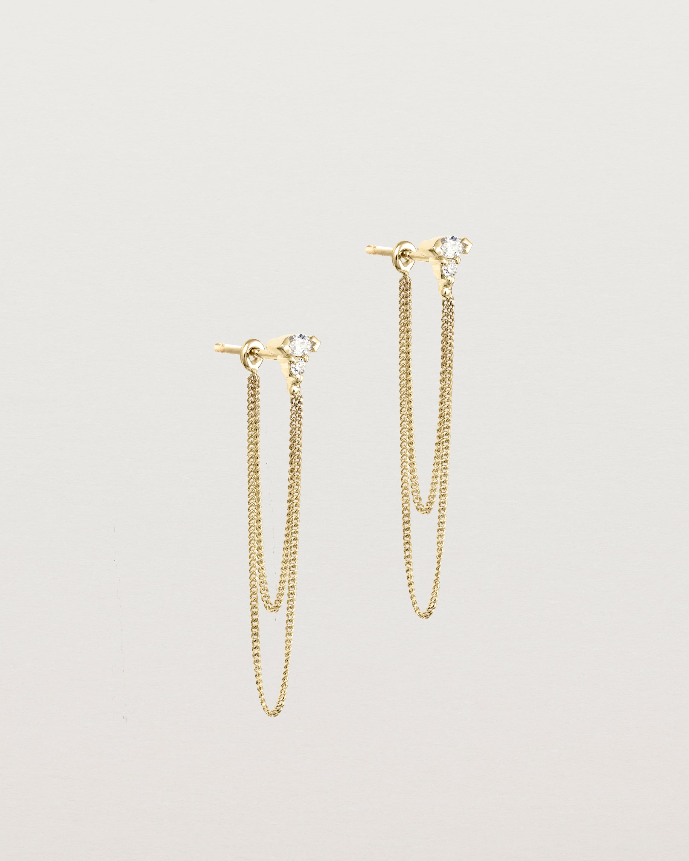 Angled view of the Vega Loop Studs | Diamonds in yellow gold.