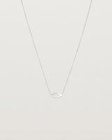 A white gold marquise disc hung on a necklace featuring a small star set white diamond