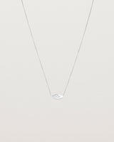 A white gold marquise disc hung on a necklace featuring a small star set white diamond
