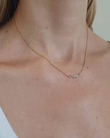 Video of model wearing ember charm necklace with blue sapphires and white diamonds.
