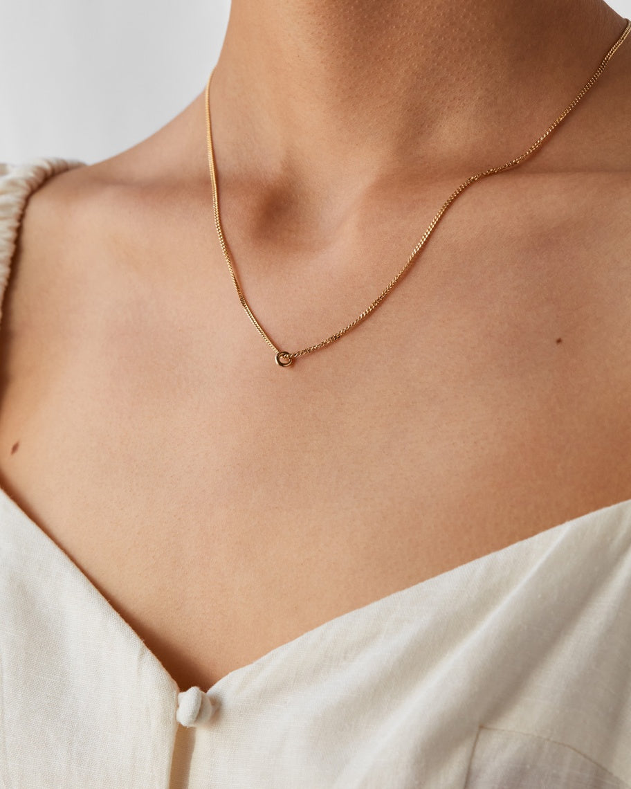 Aether Necklace in Yellow Gold with a singular charm.