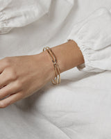 A woman wearing the Ailing Cuff Bangle in yellow gold.