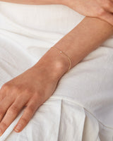 A woman wearing the Aiona Bracelet in yellow gold.