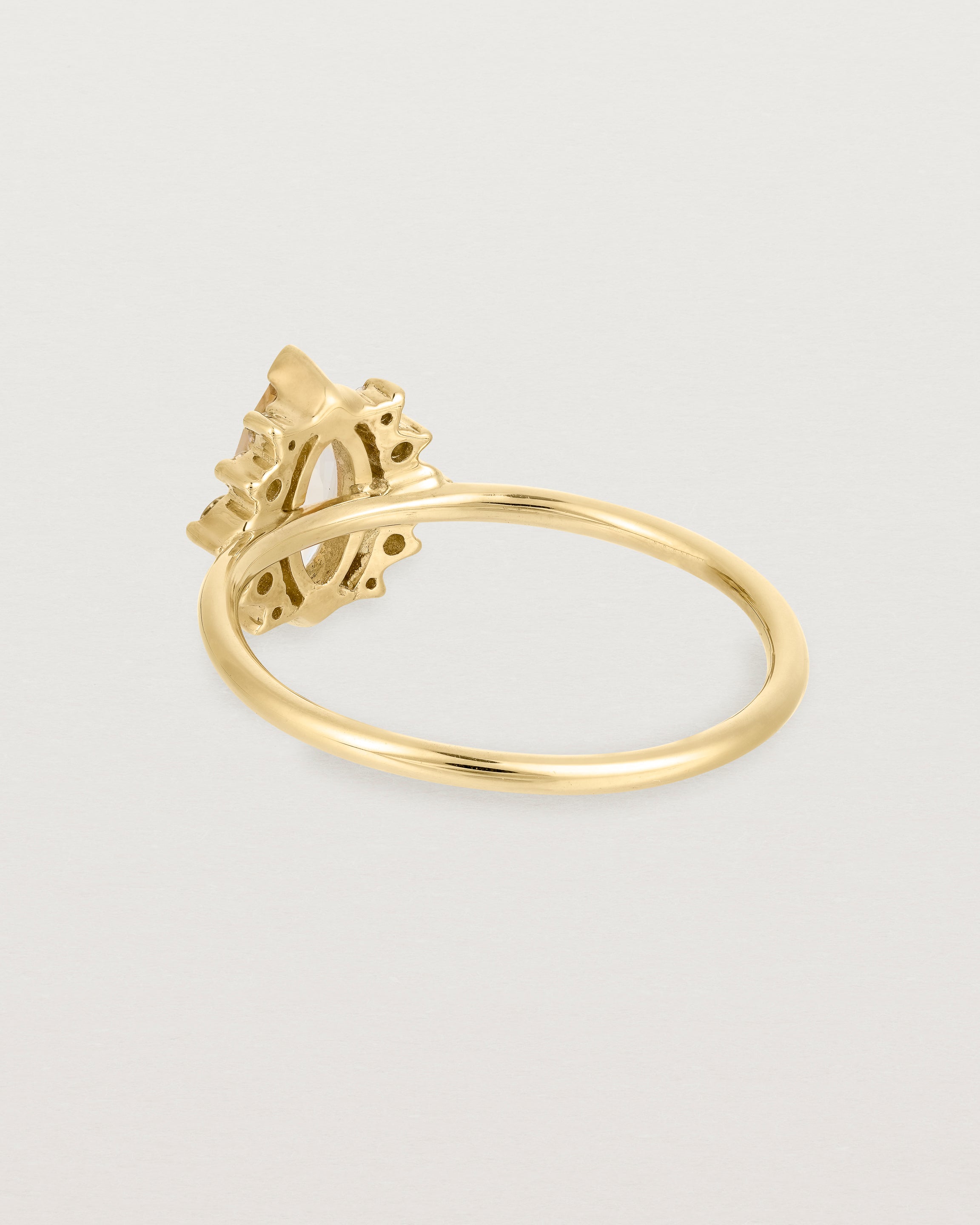 A yellow gold ring featuring a marquise champagne quartz with a halo of white diamonds