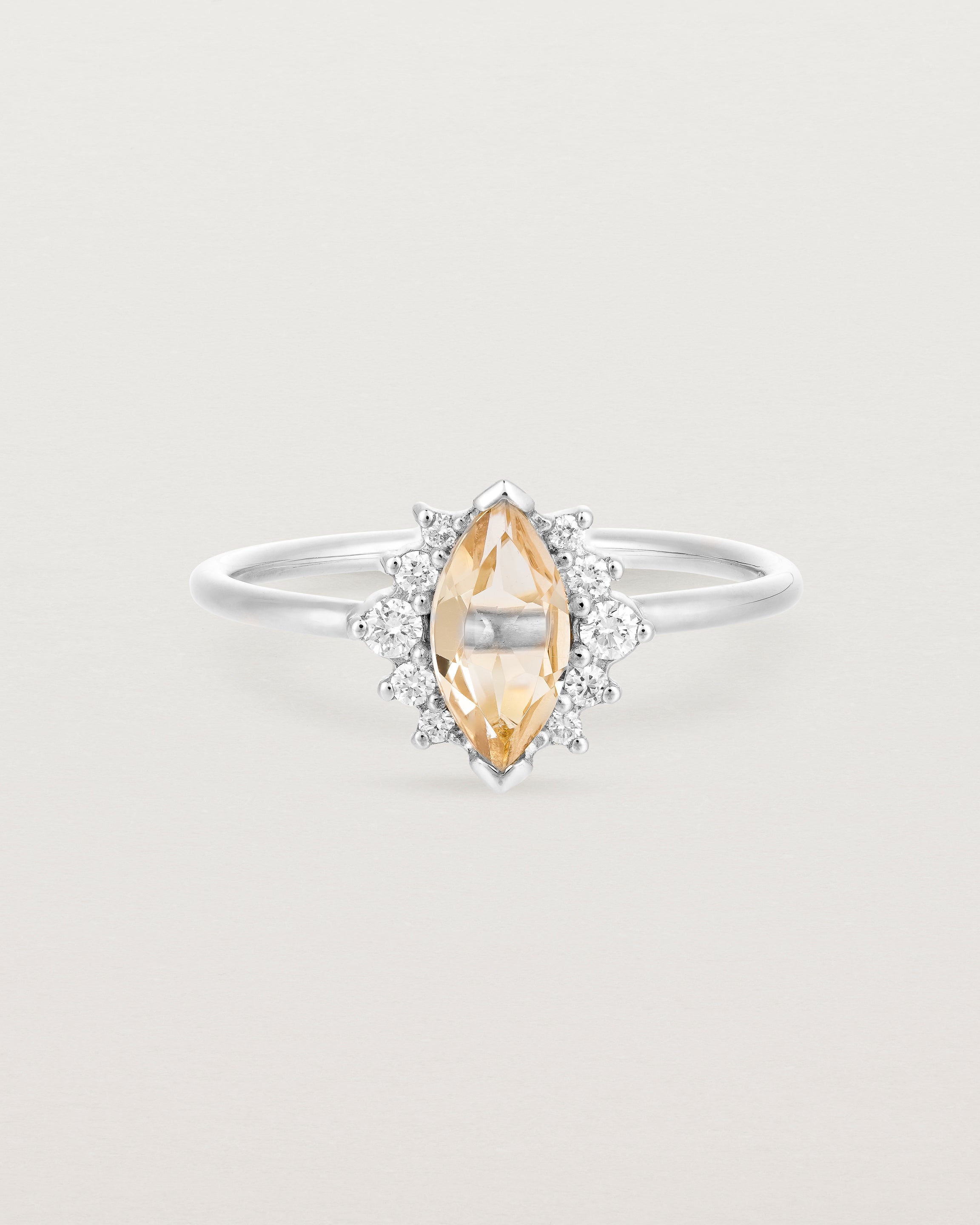 A white gold ring featuring a marquise champagne quartz with a halo of white diamonds