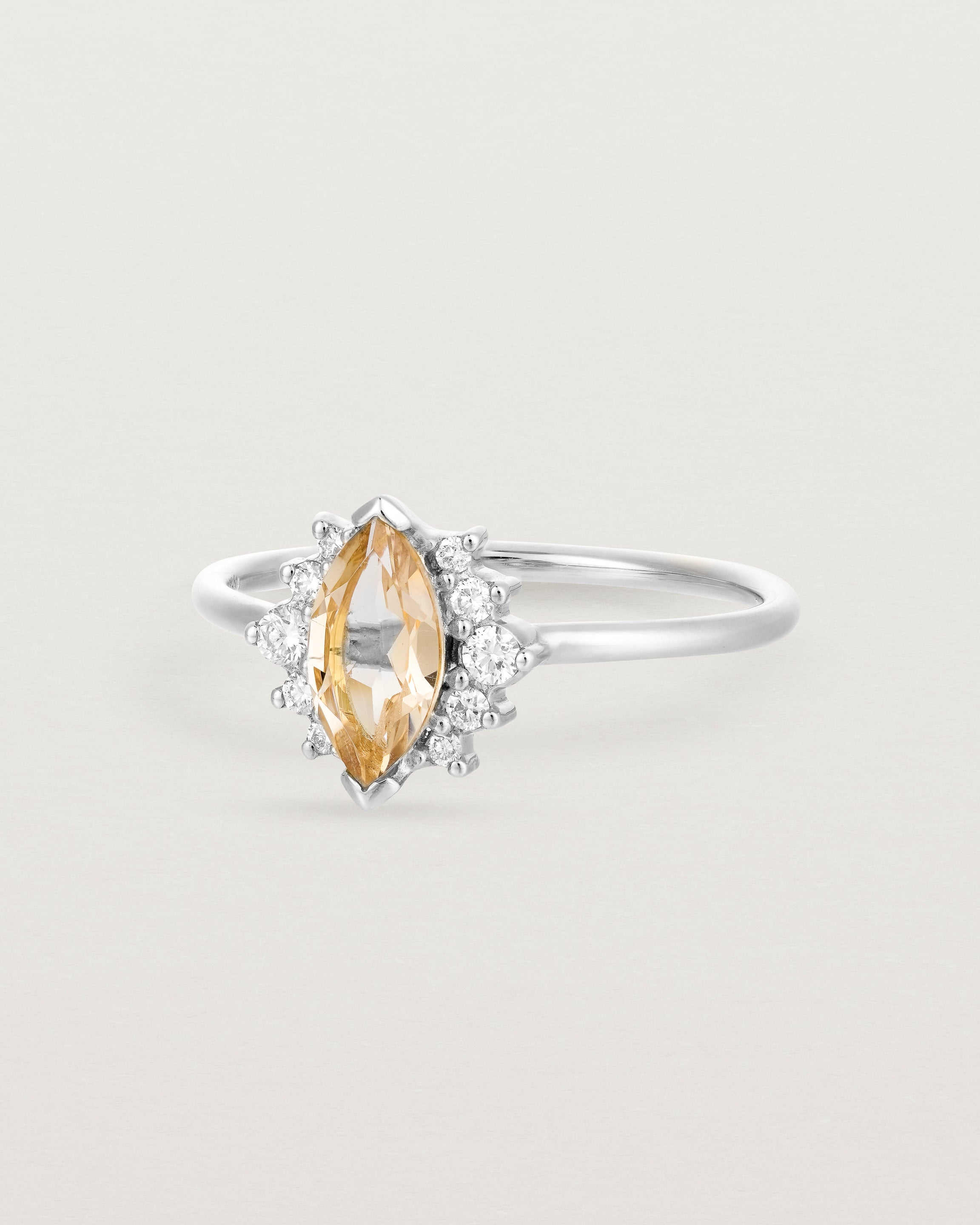 A white gold ring featuring a marquise champagne quartz with a halo of white diamonds