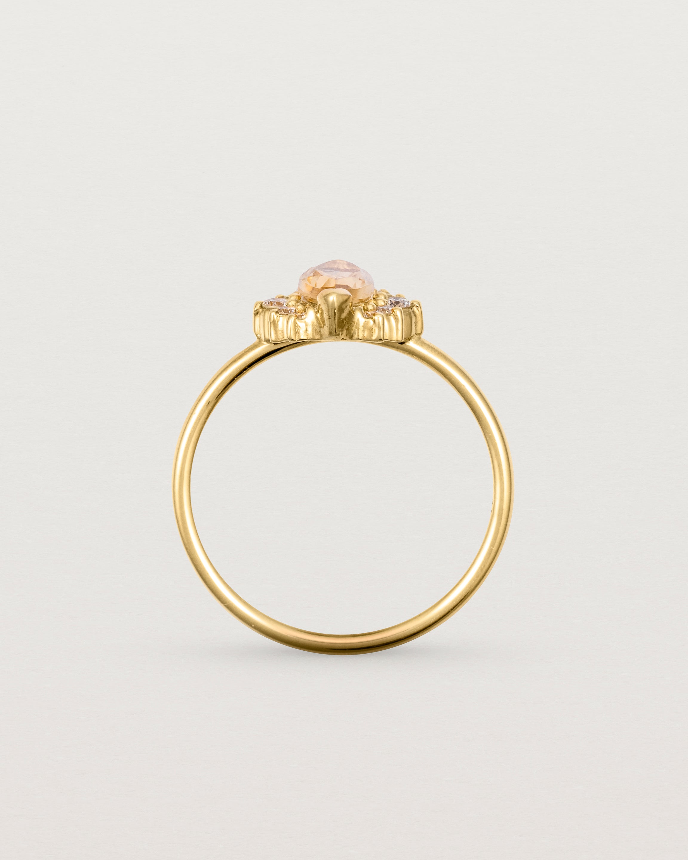 A yellow gold ring featuring a marquise champagne quartz with a halo of white diamonds