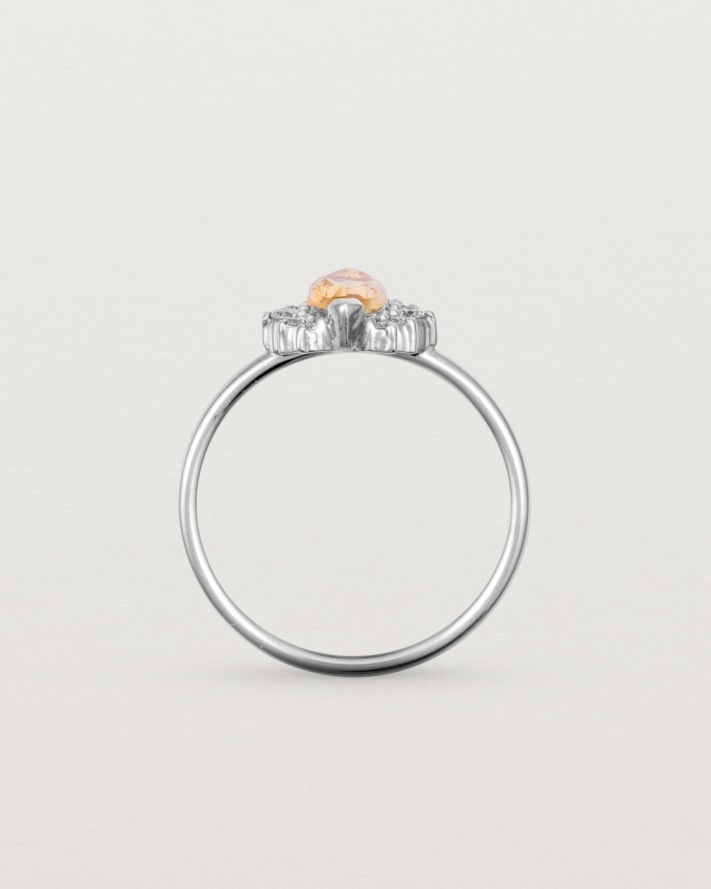 A white gold ring featuring a marquise champagne quartz with a halo of white diamonds