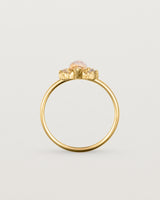 A yellow gold ring featuring a marquise champagne quartz with a halo of white diamonds