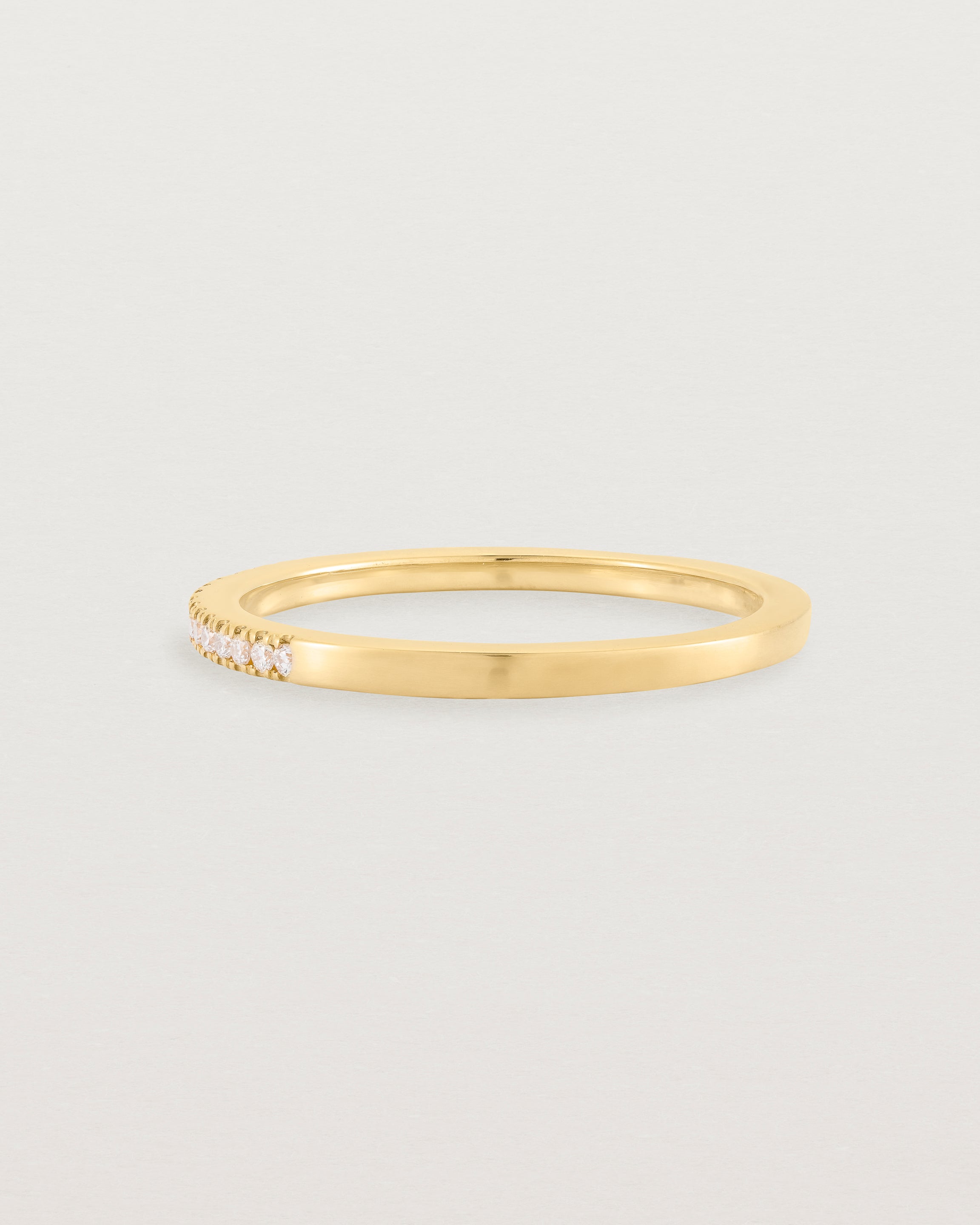 yellow gold band with half a band of micro pave diamonds