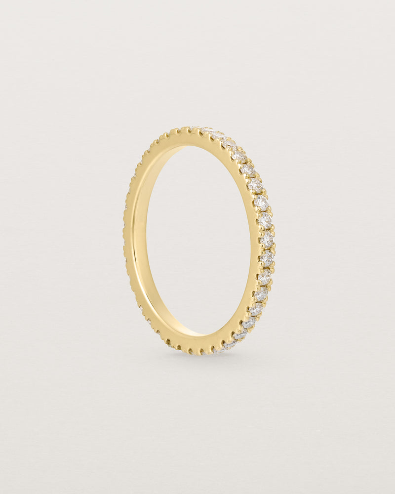 a yellow gold band with white diamonds