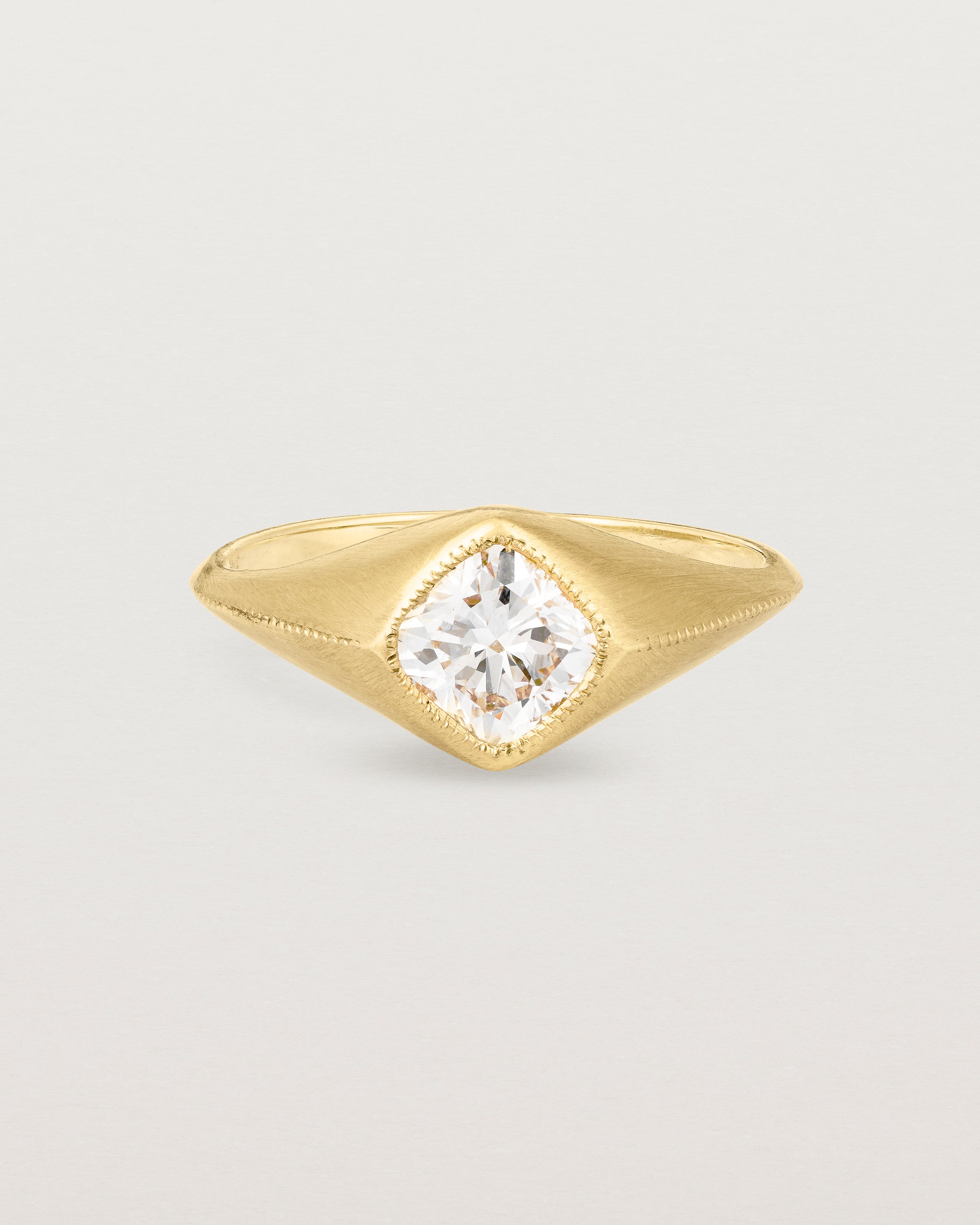 A yellow gold Signet Ring featuring a cushion cut white diamond