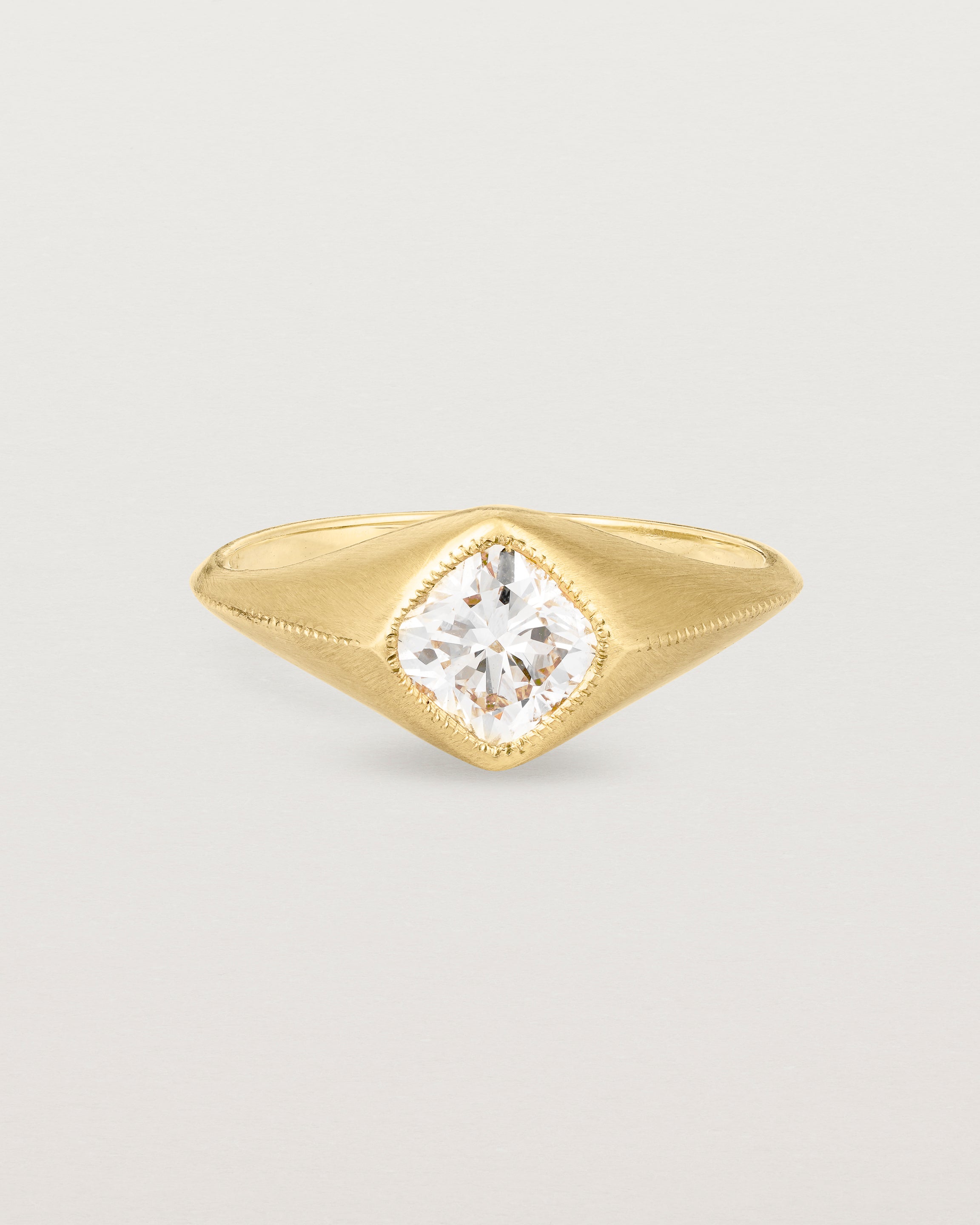 A yellow gold Signet Ring featuring a cushion cut white diamond