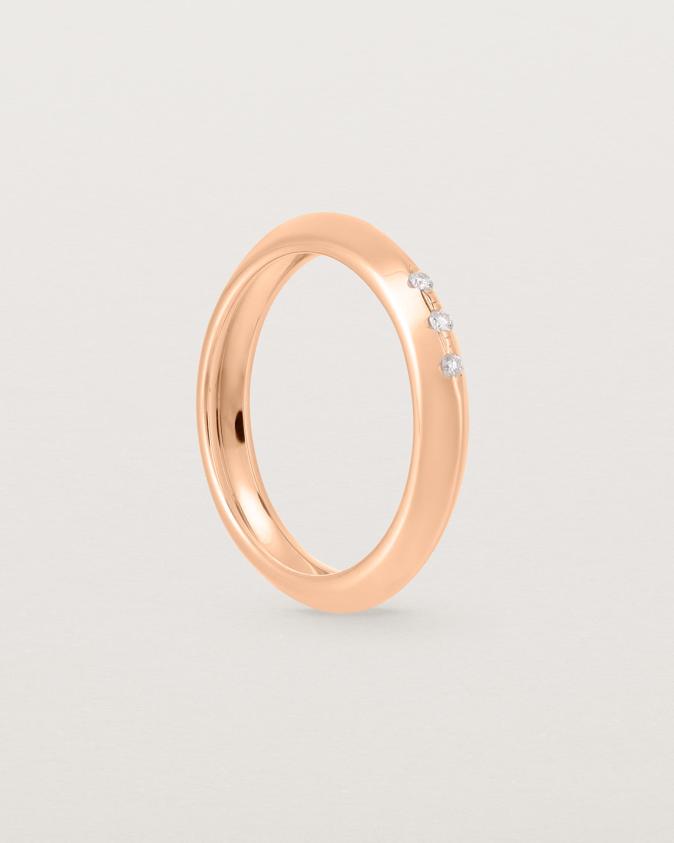 A rose gold ring with white diamonds