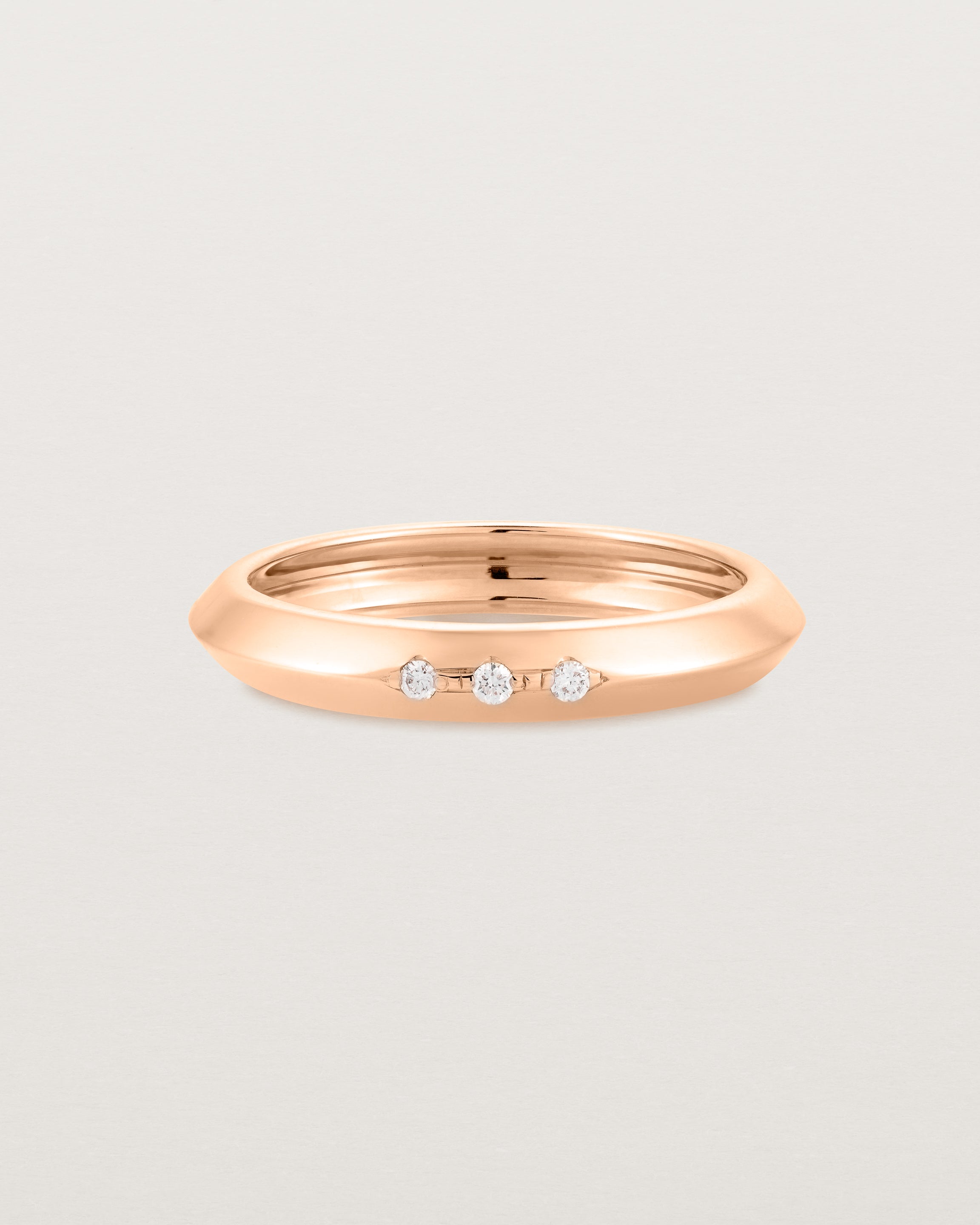 A rose gold ring with white diamonds