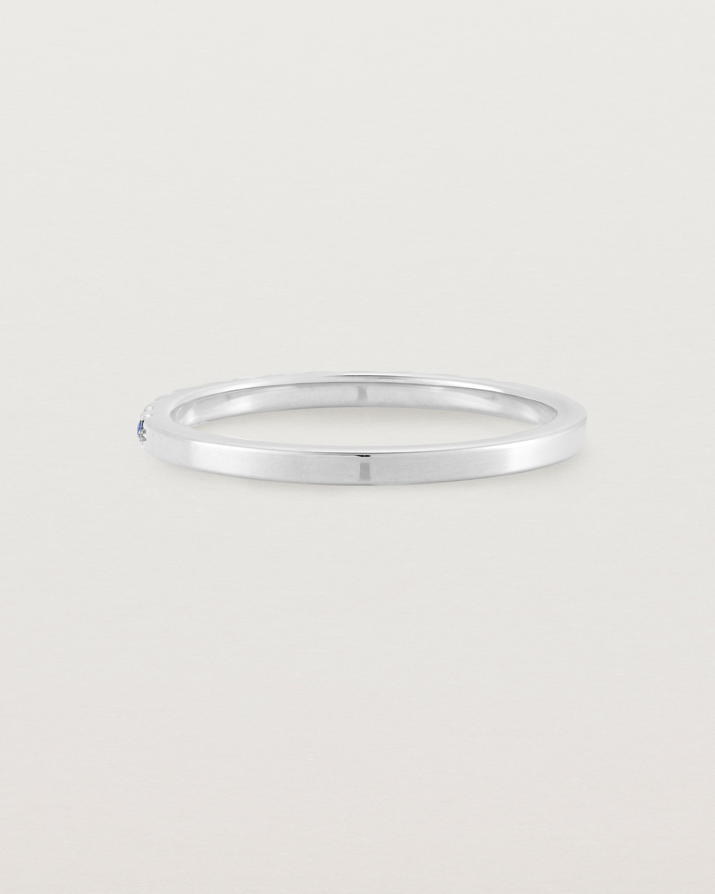 A fine white  gold wedding ring with thirteen blue sapphires