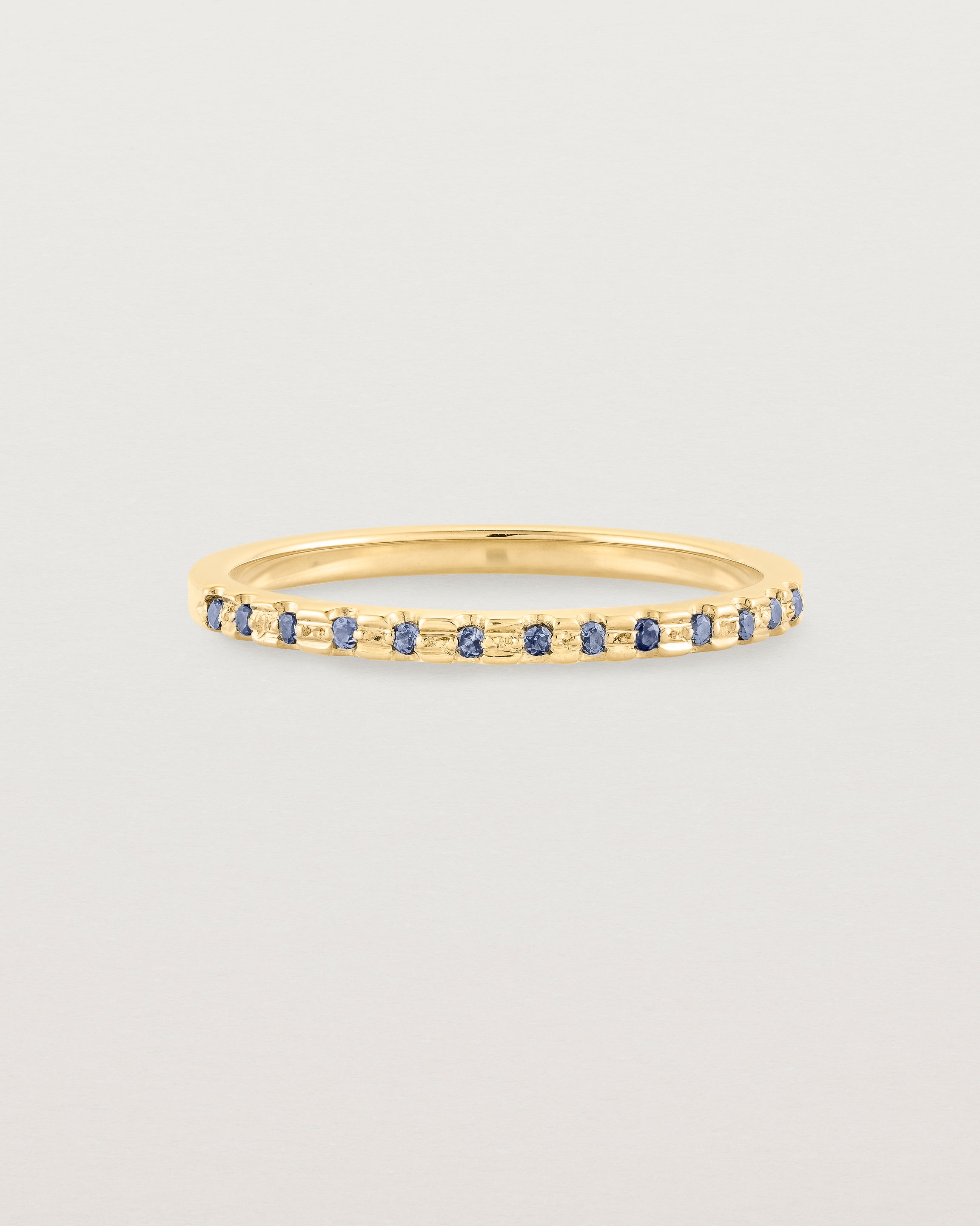 A fine yellow gold wedding ring with thirteen blue sapphires
