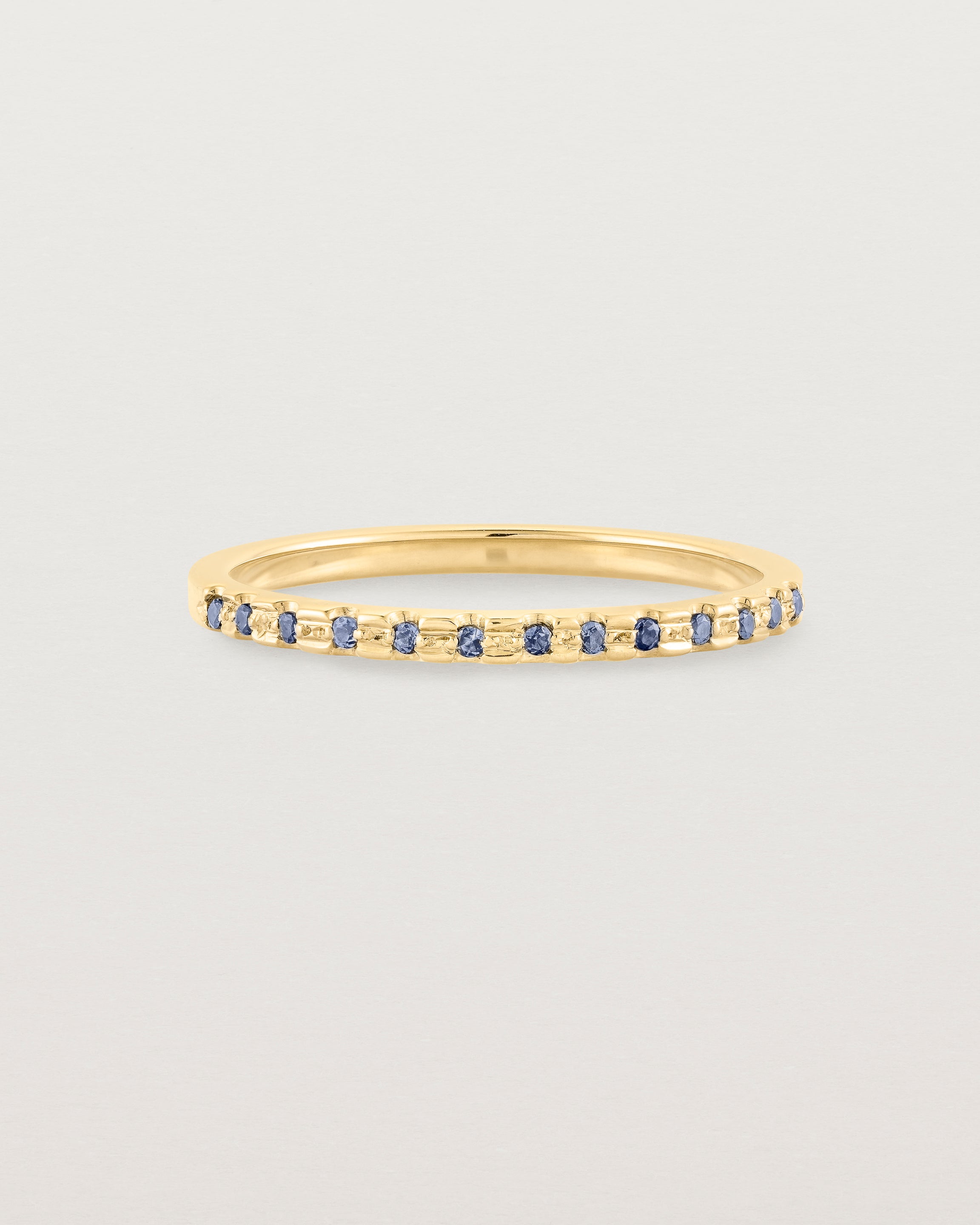 A fine yellow gold wedding ring with thirteen blue sapphires